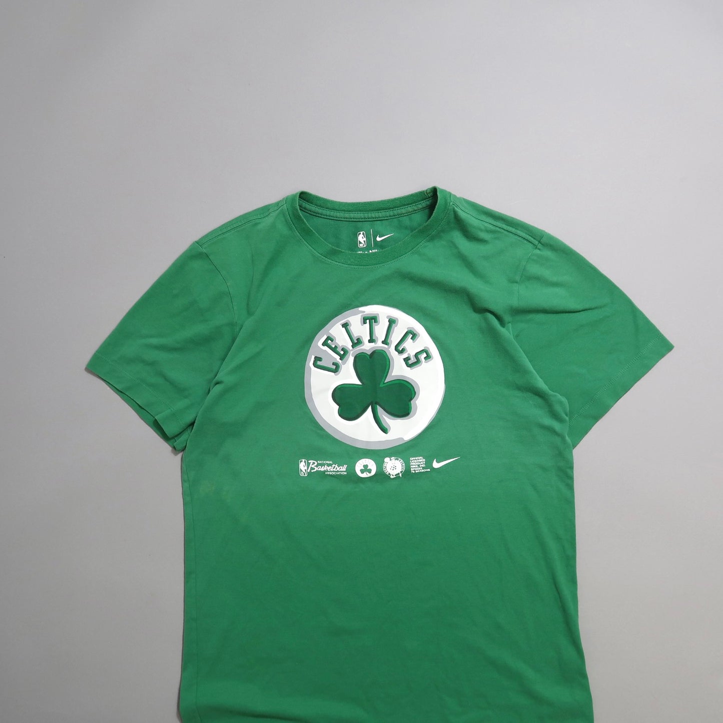 Green T-shirt with Celtics logo and shamrock design on front.