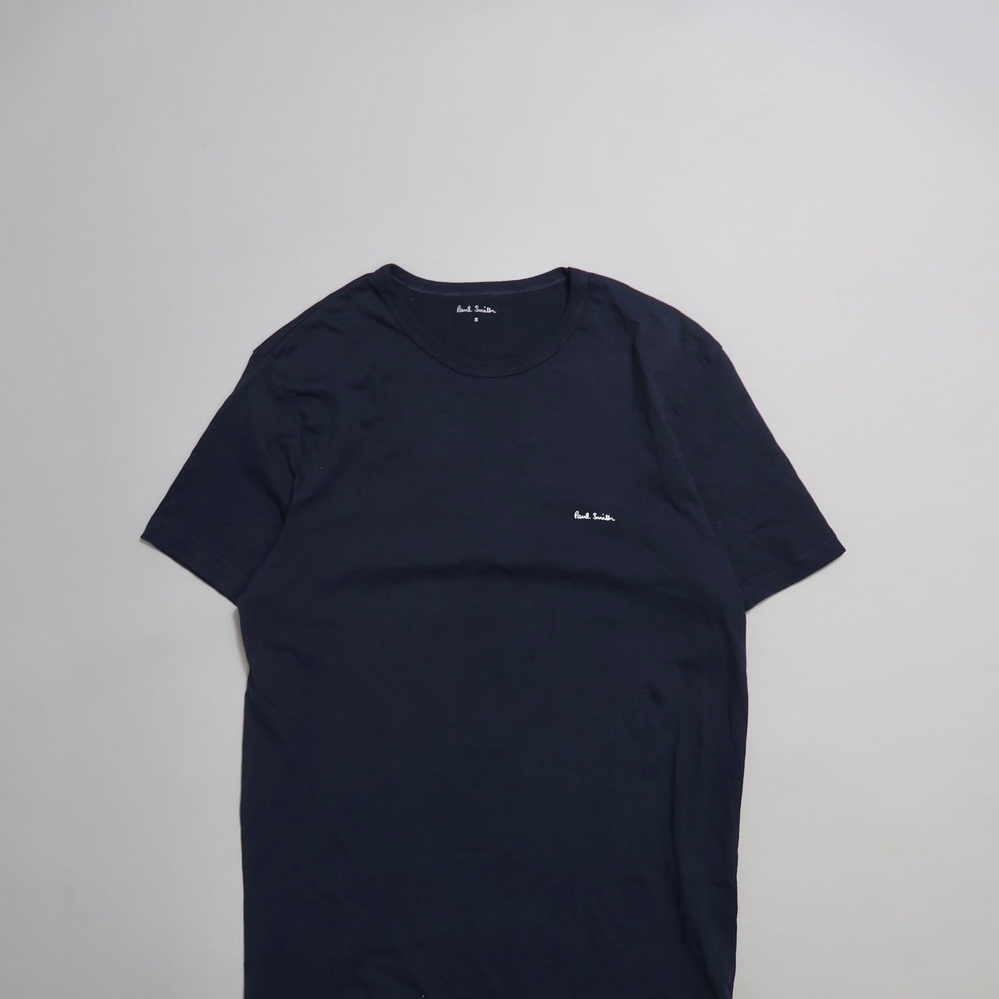 Plain black T-shirt with small white embroidered logo.