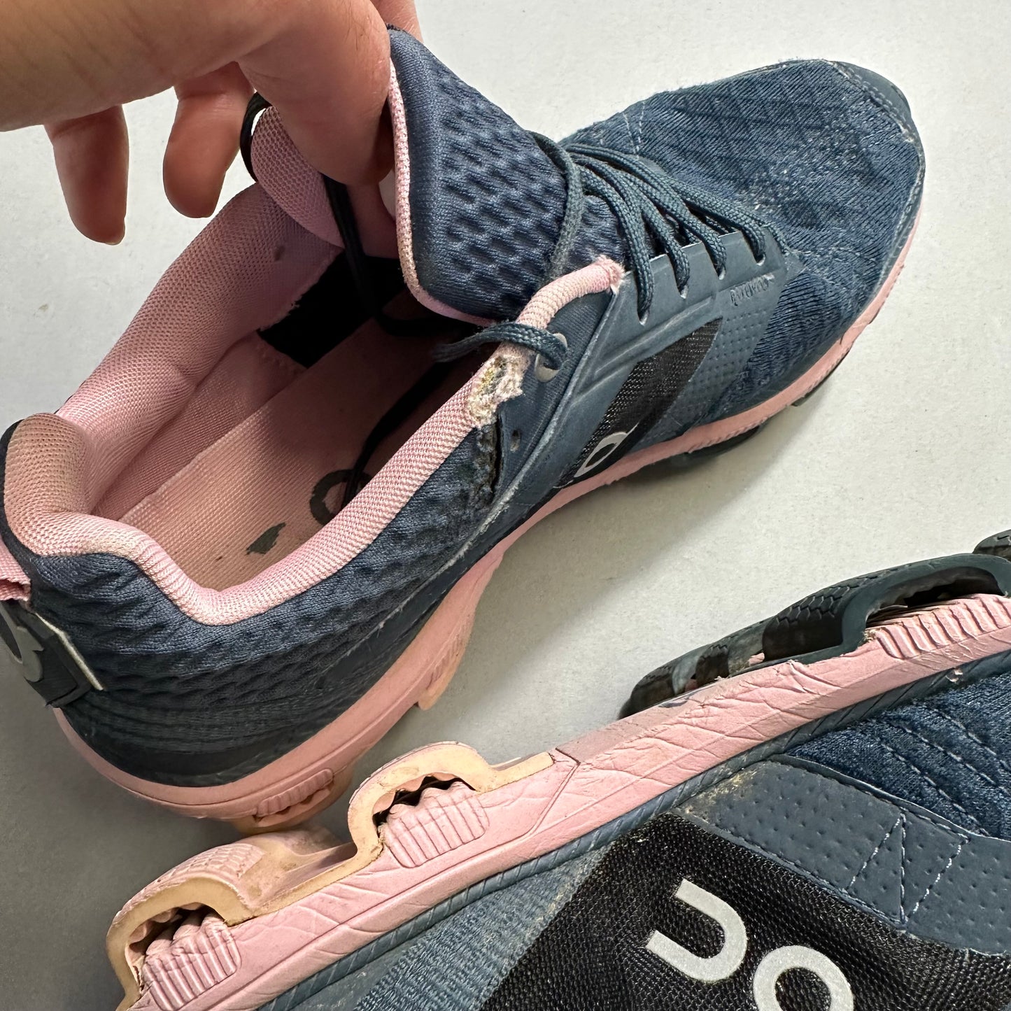 Worn blue and pink running shoes with visible damage.
