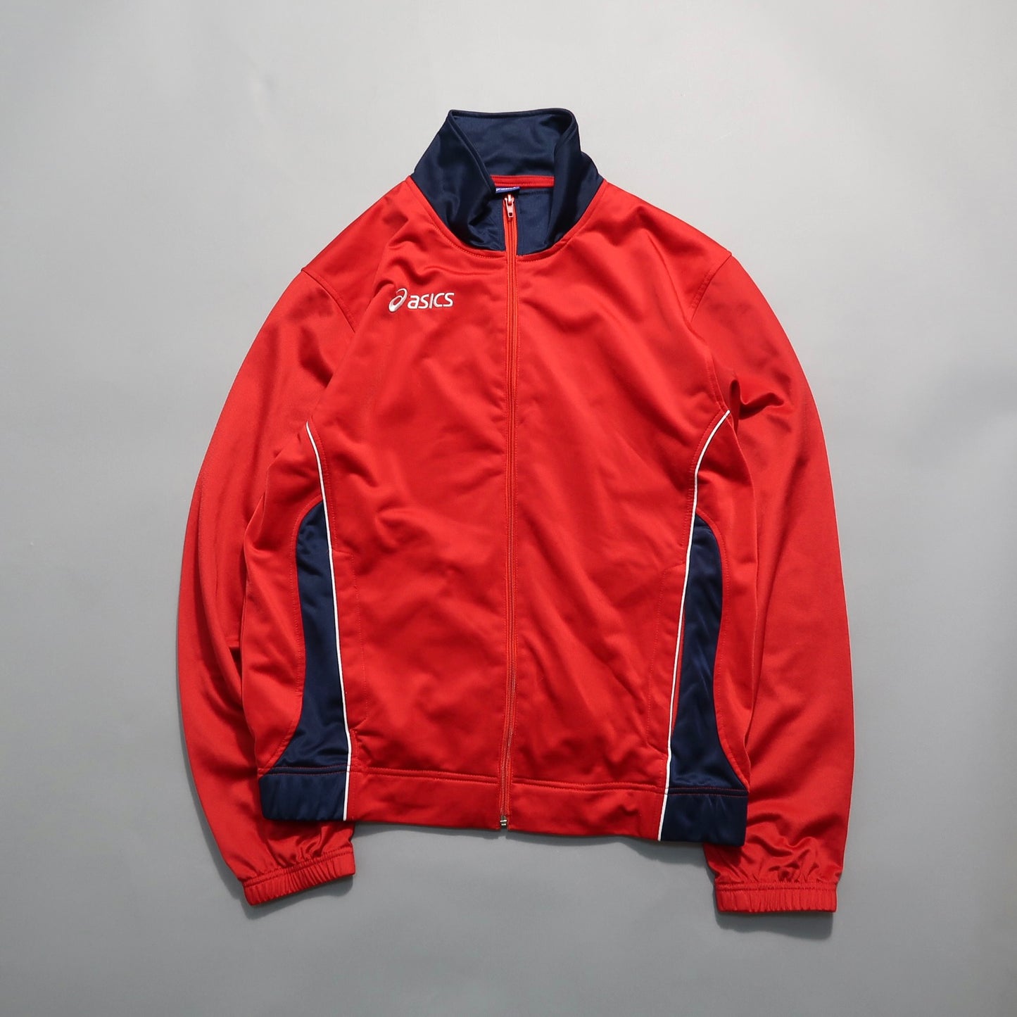 Red and navy Asics track jacket with a zipper and white piping.