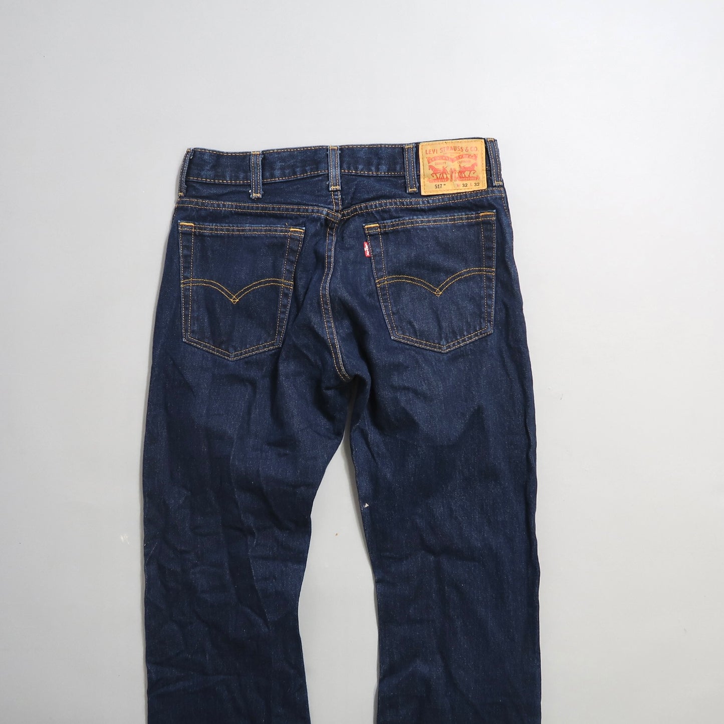 Denim jeans back view with visible label and stitching.