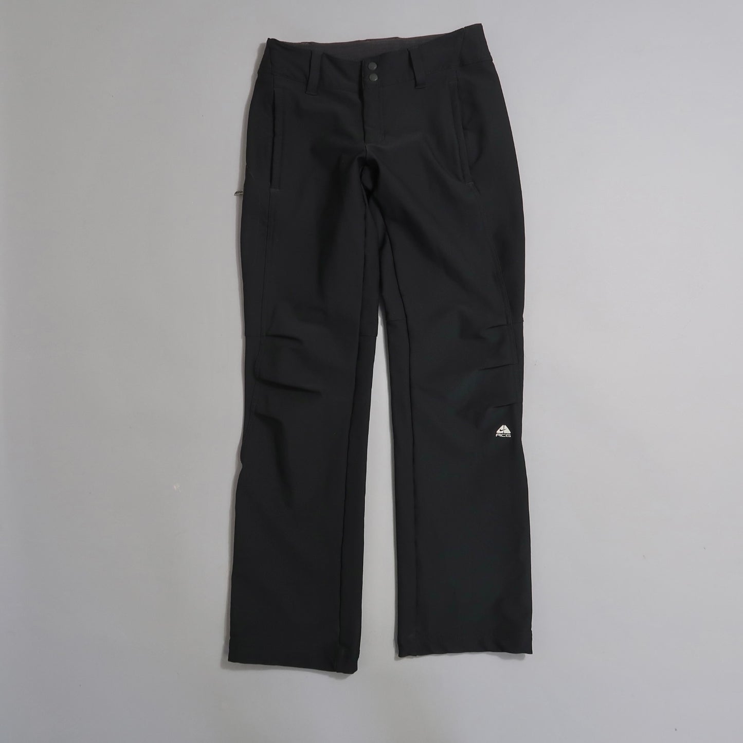 Black pants with pockets and a logo on the left leg.
