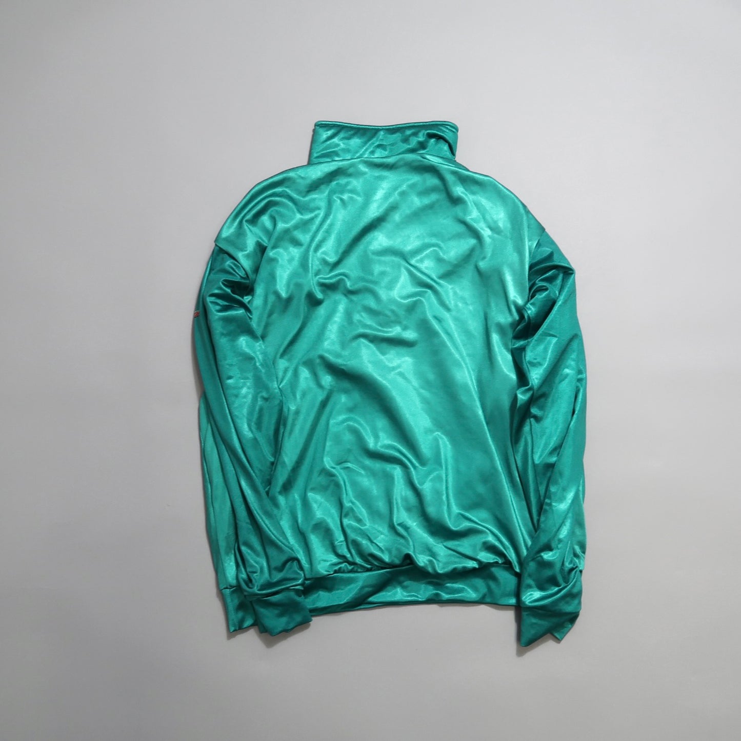 Teal satin jacket with a high collar, laid flat on a gray background.