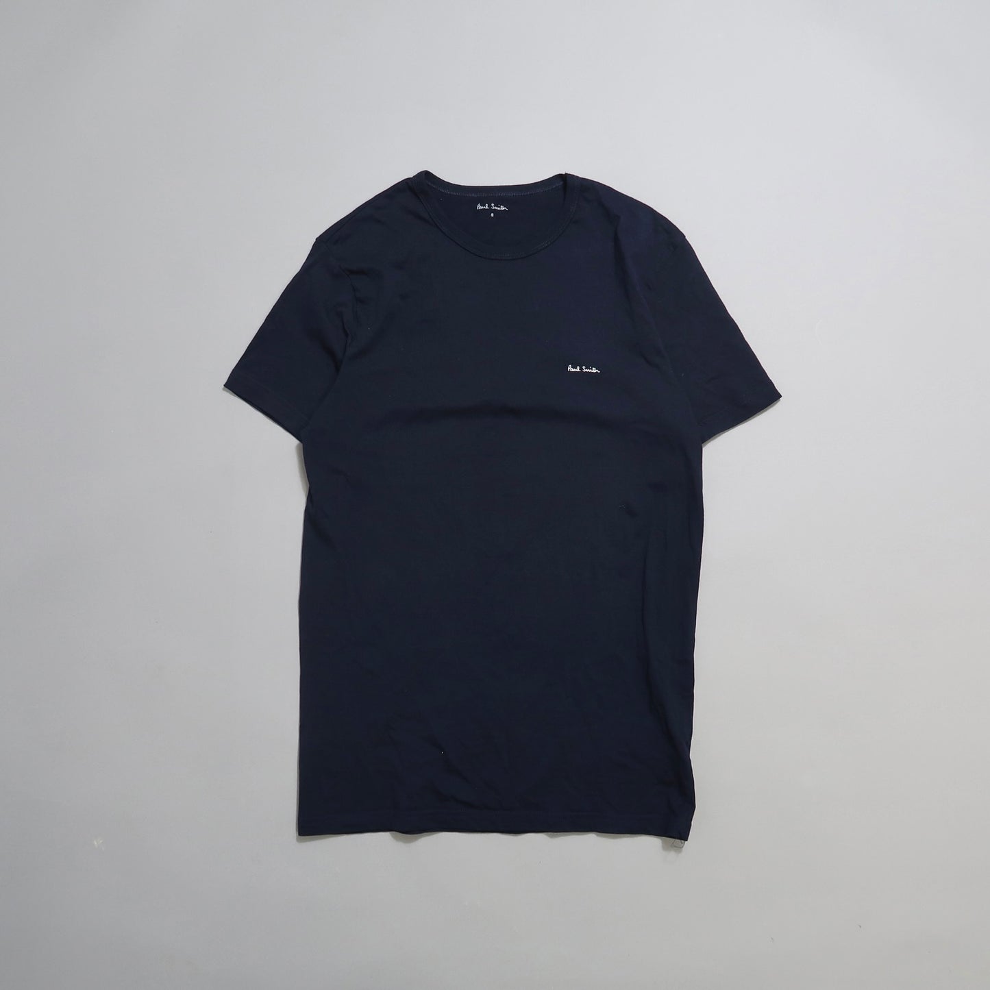 Dark blue T-shirt on a light gray background.