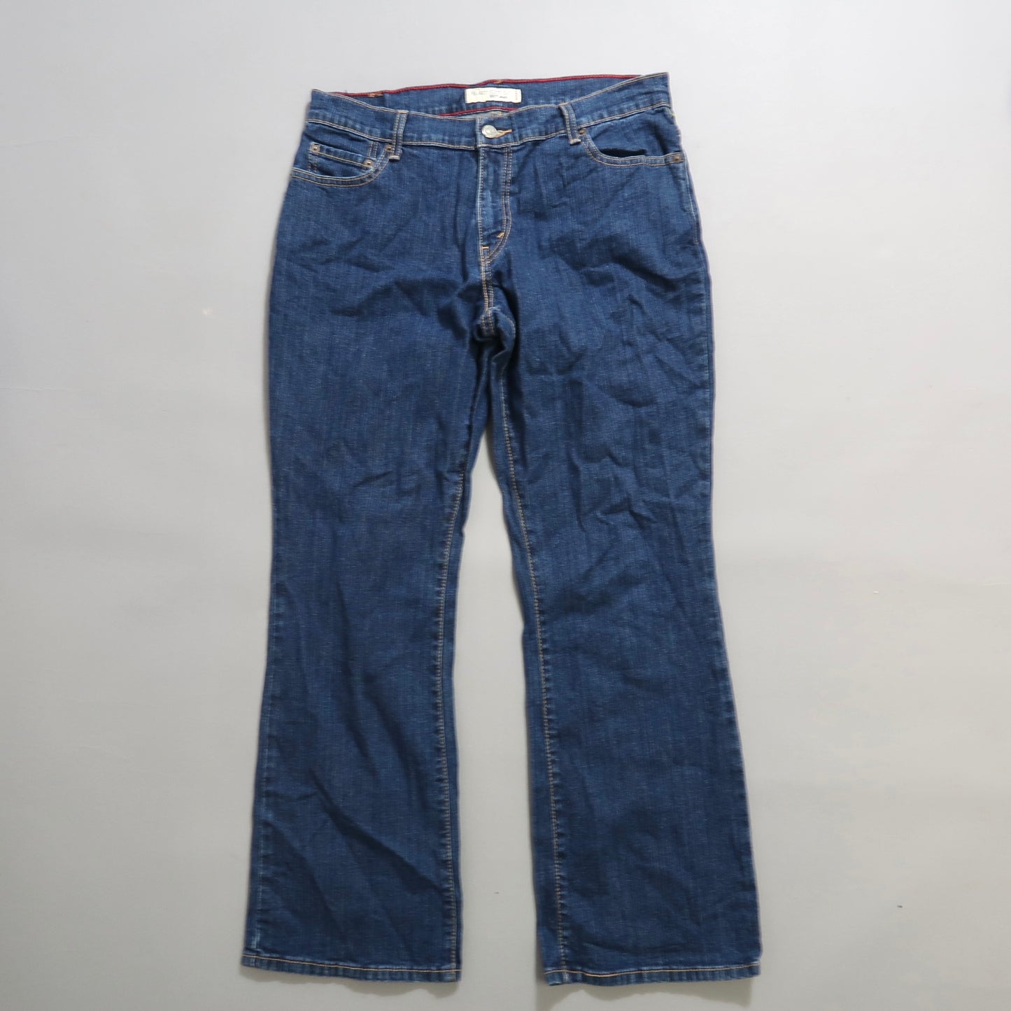 Dark blue denim jeans on a plain background.
