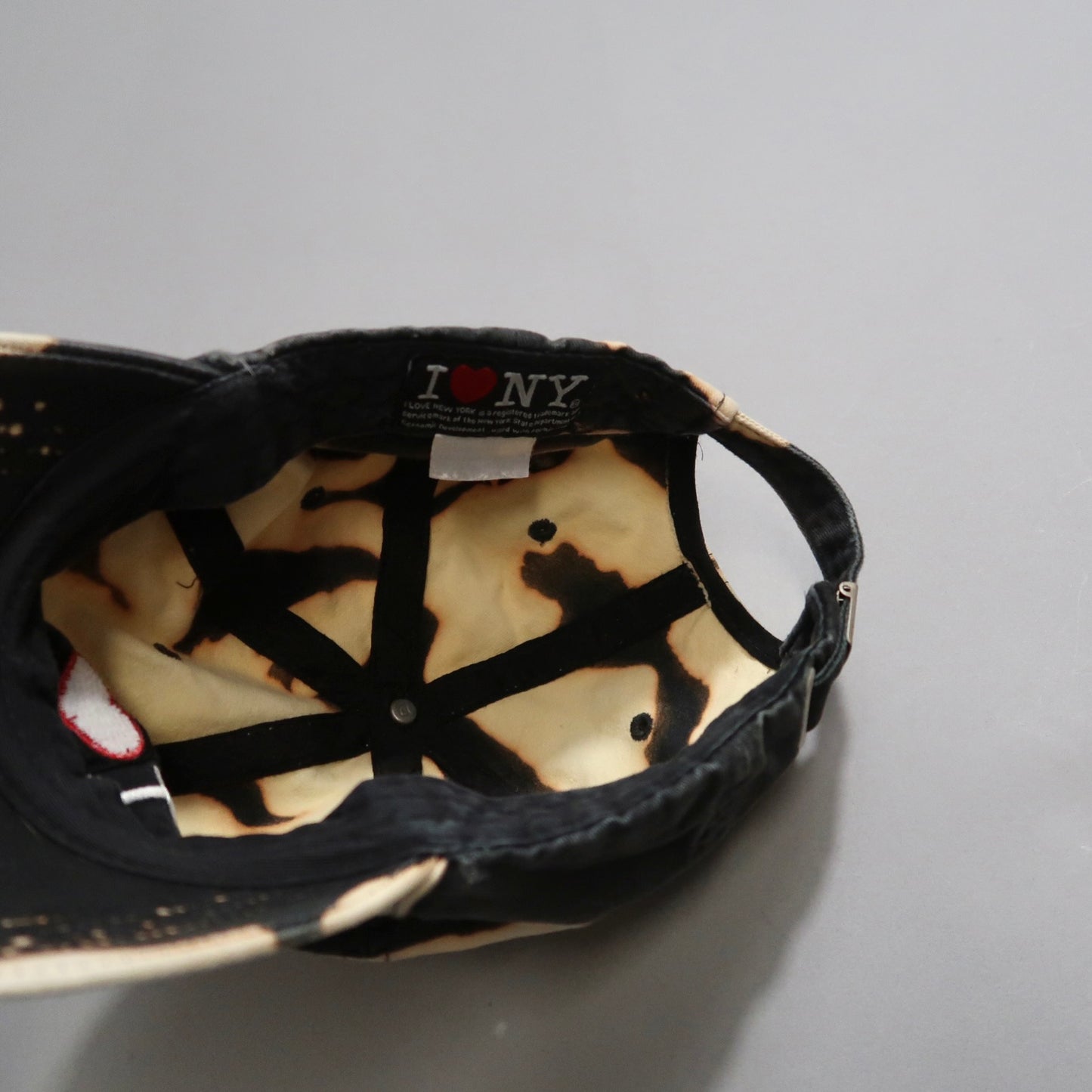 Inside view of a cap showing nullI ♥ NYnull label and tie-dye pattern.