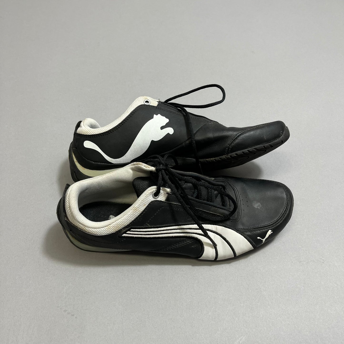 Black and white sports shoes with a pouncing cat logo.