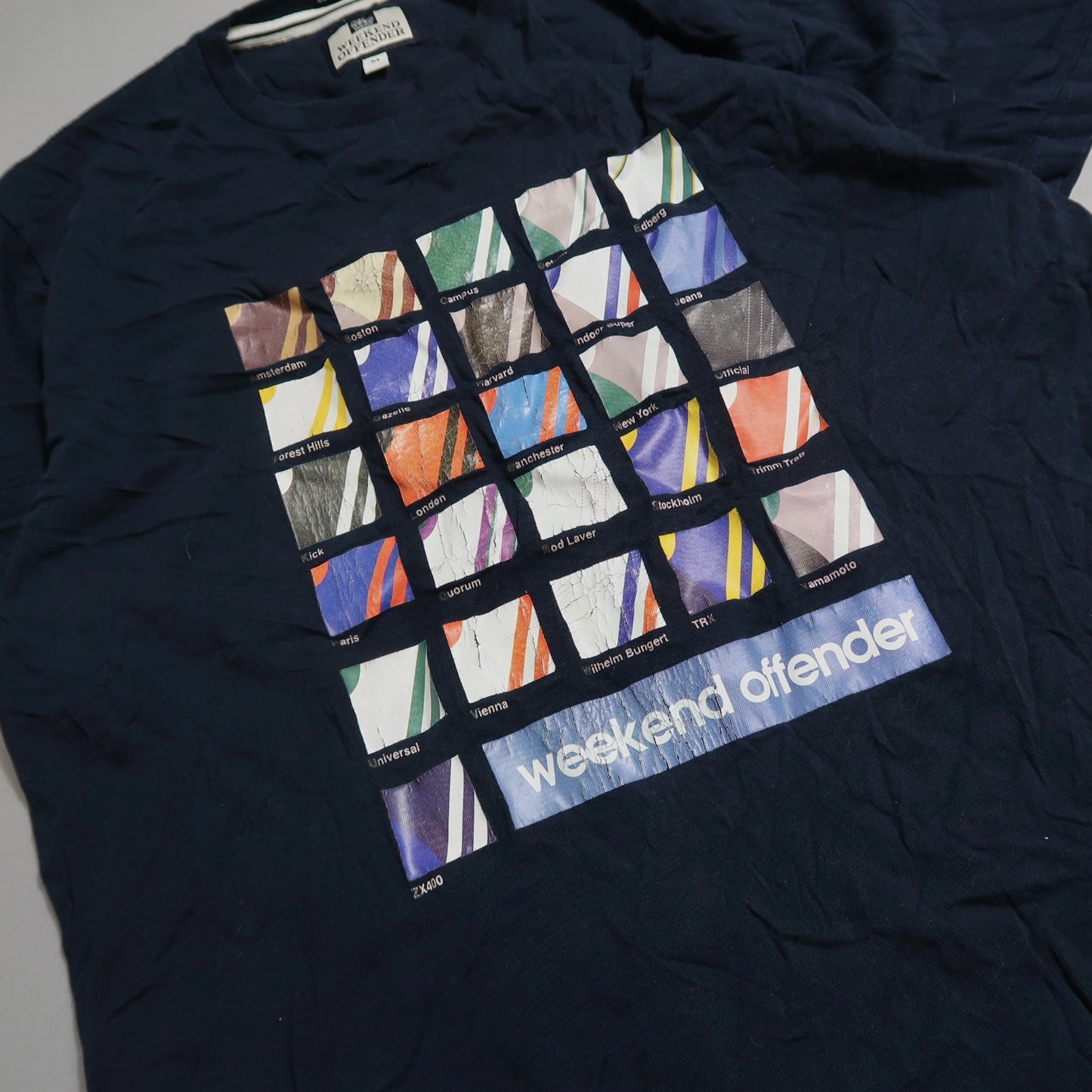 Navy t-shirt with colorful grid design and nullweekend offendernull text.