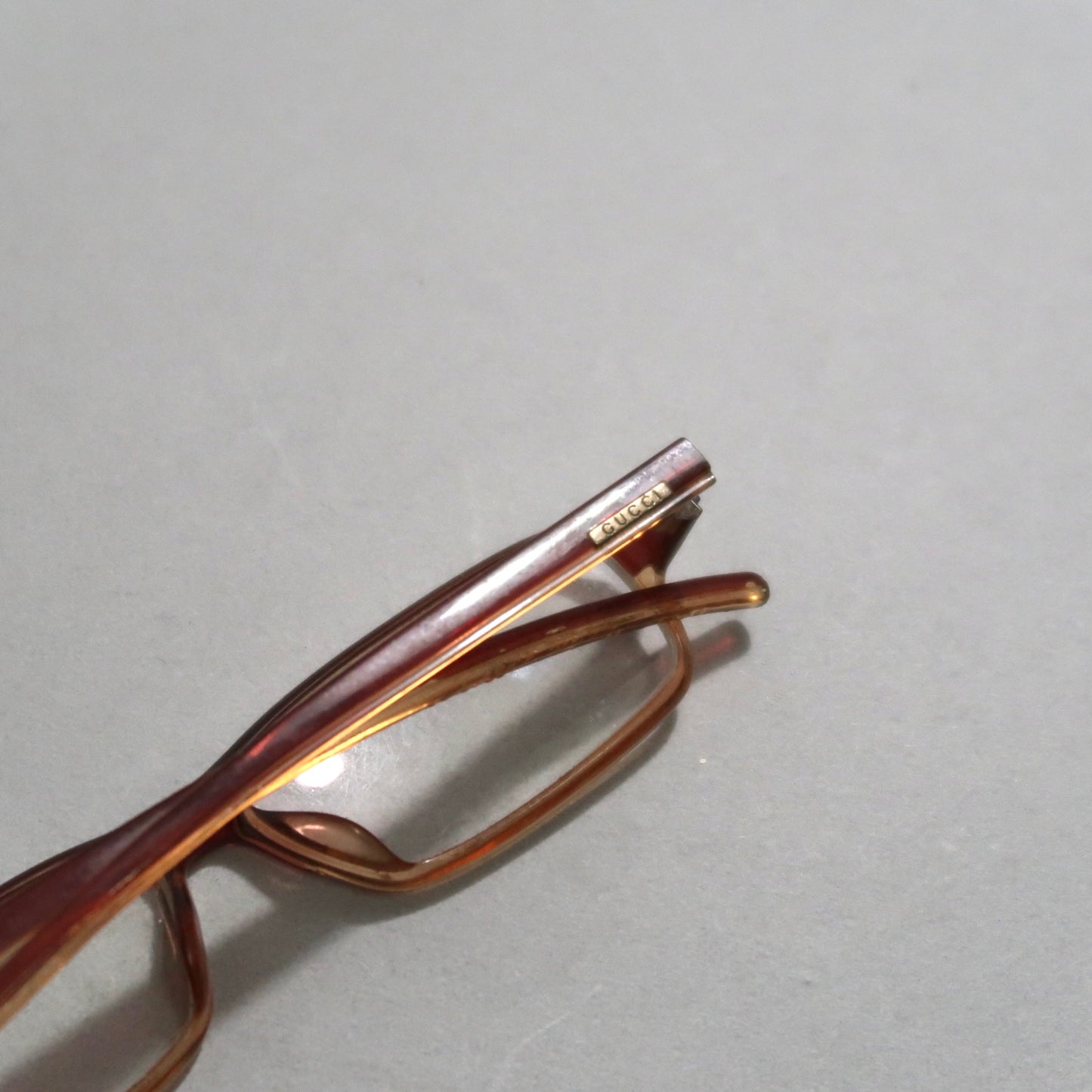 Brown glasses with gold nullGuccinull logo on the temple.