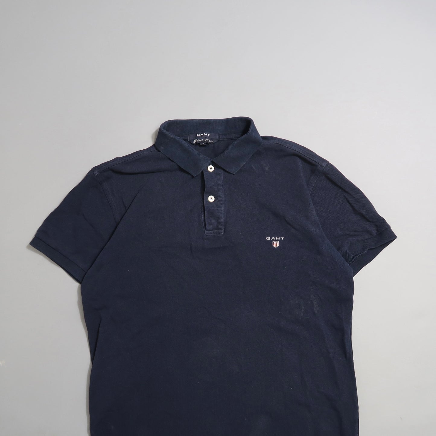 Navy blue polo shirt with collar, buttons, and small logo.