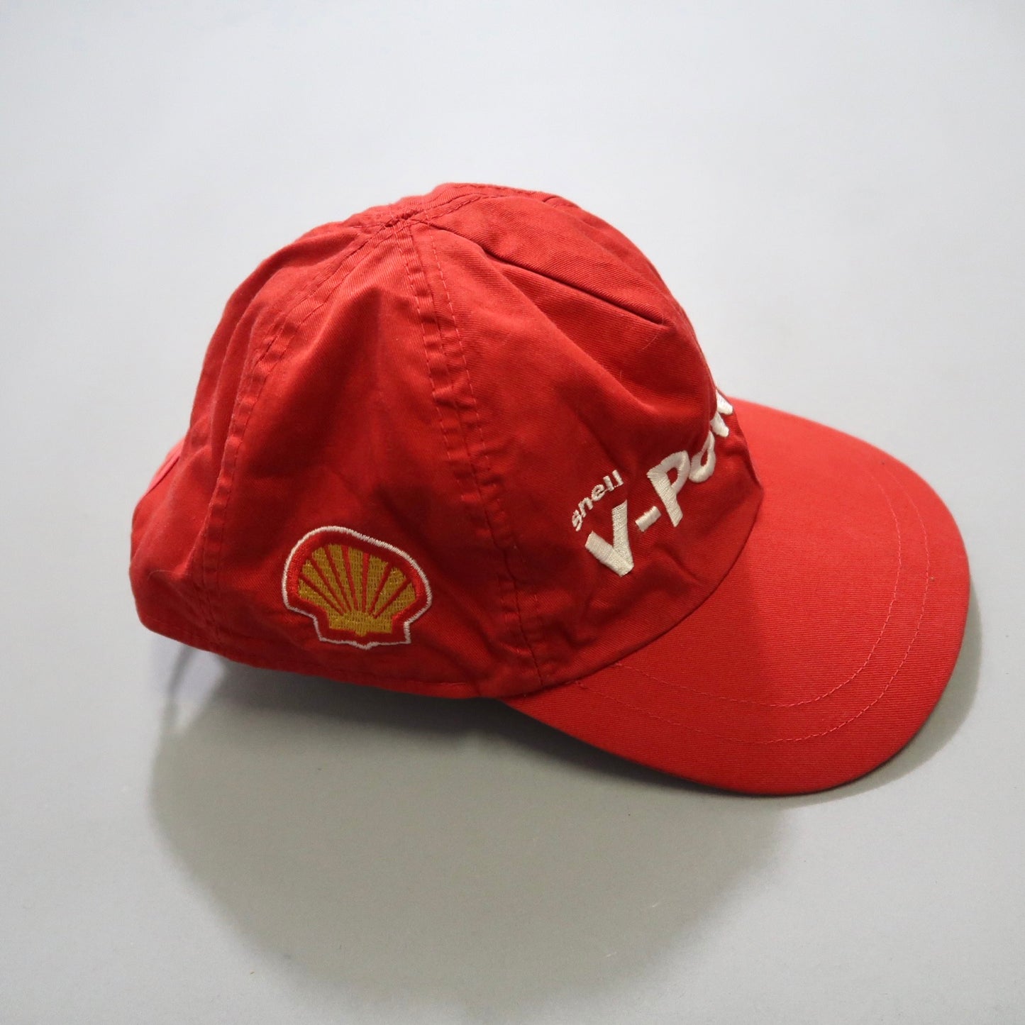 Red cap featuring Shell and V-Power logos, placed on a flat surface.