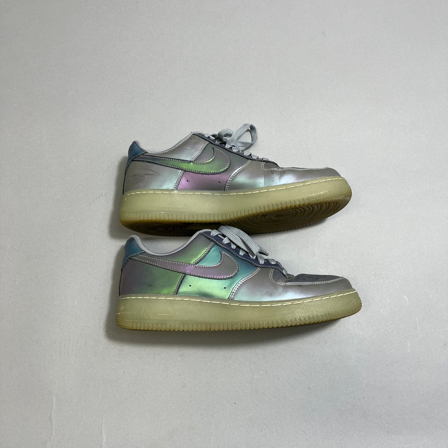 Iridescent sneakers with gum soles on a white background.