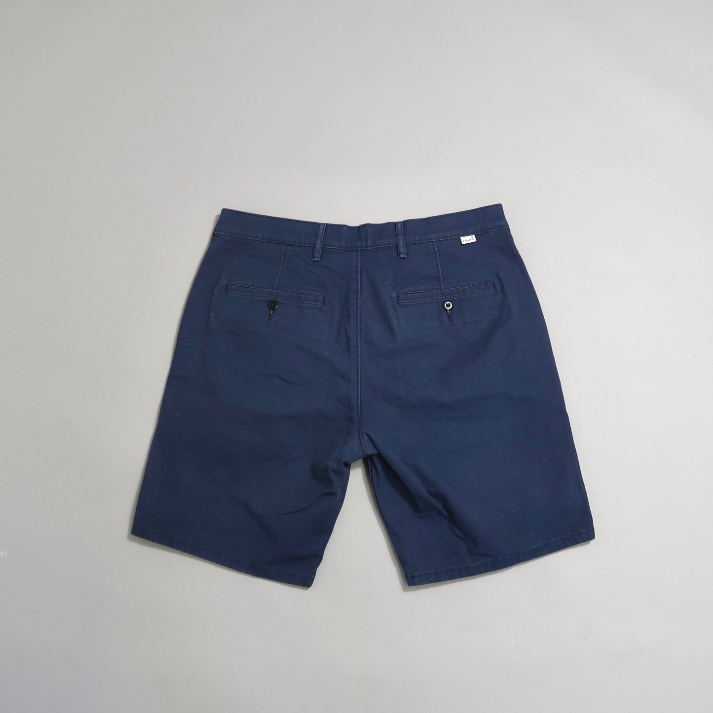 Navy blue shorts with belt loops and back pockets, laid flat.
