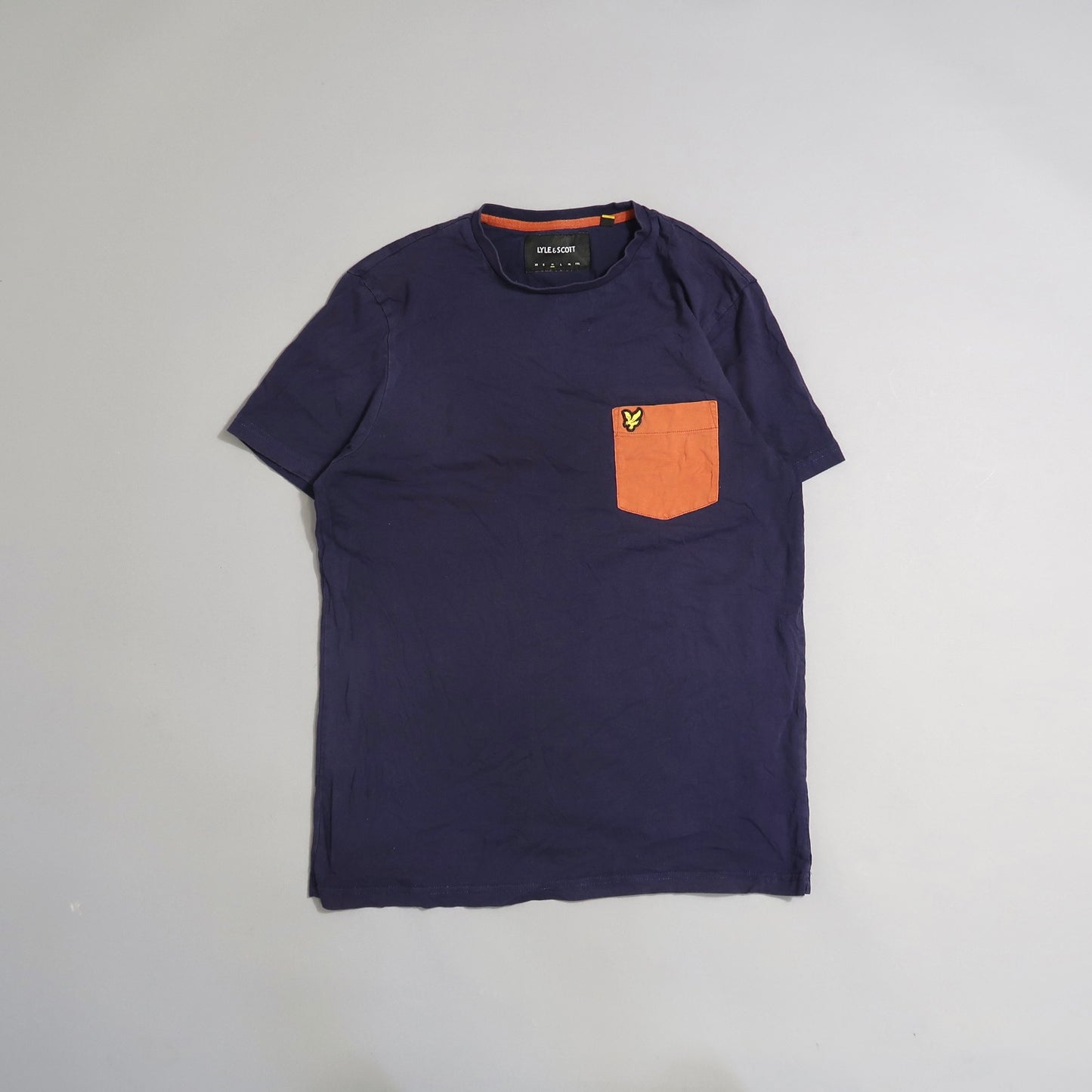 Navy T-shirt with an orange pocket and small logo on chest.