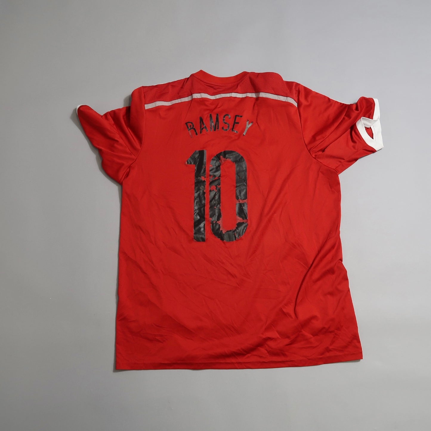 Red sports jersey with nullRamsey 10null on the back, lying flat.