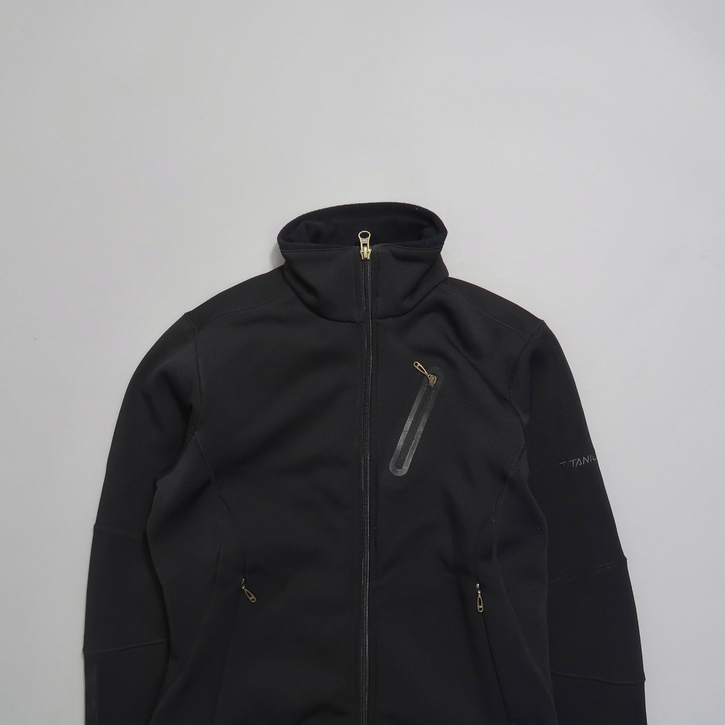 Black zip-up jacket with high collar and multiple pockets.