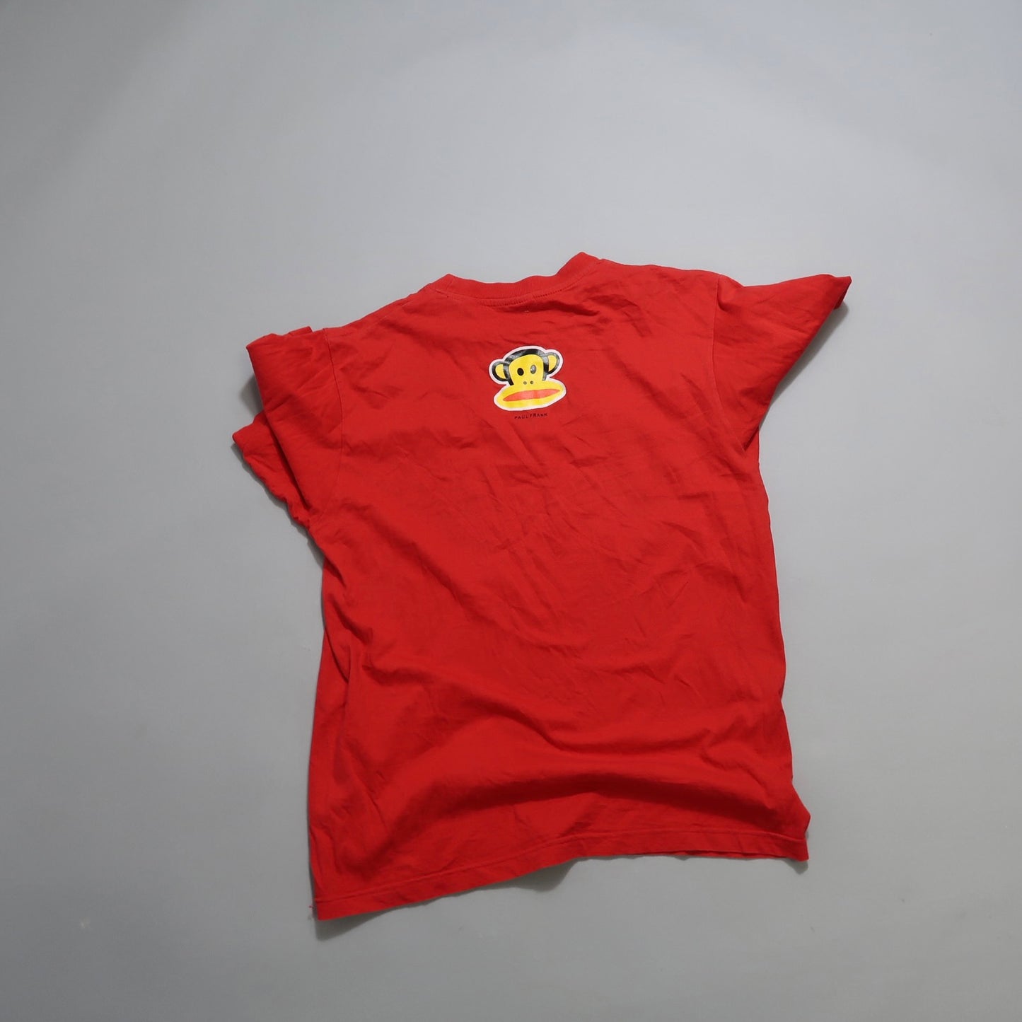 Red T-shirt with a monkey face logo on the back.