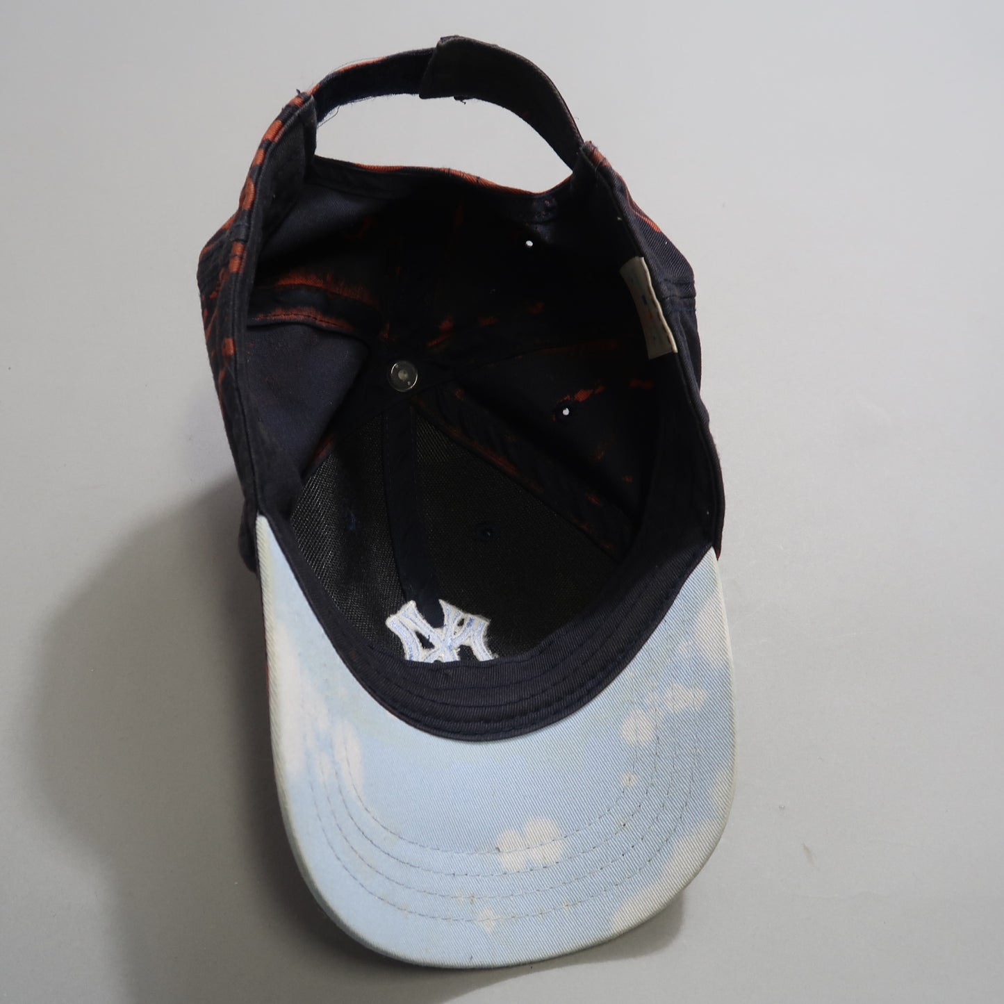 Inside view of a worn baseball cap with a light-colored brim.