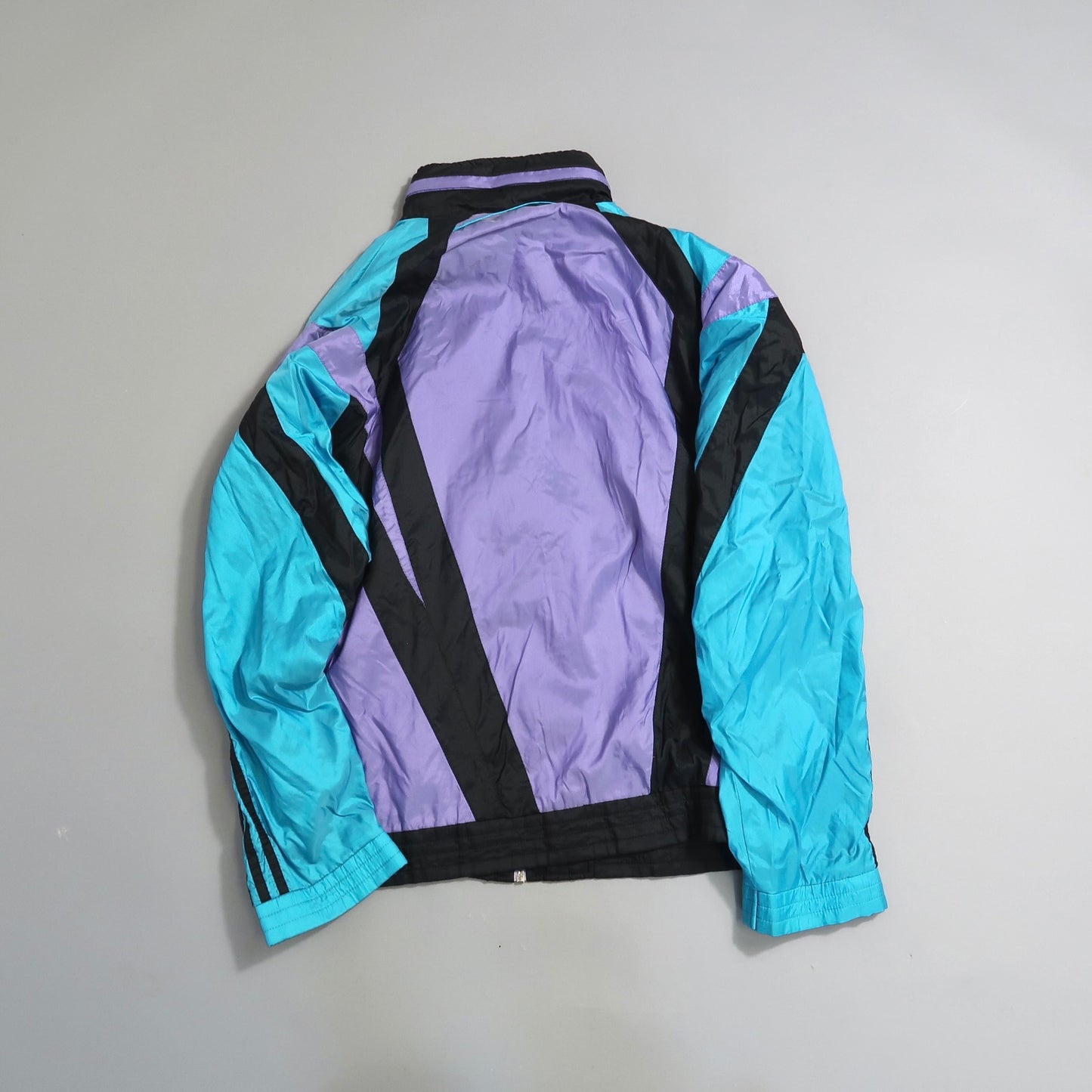 Retro turquoise and purple windbreaker jacket, black accents.