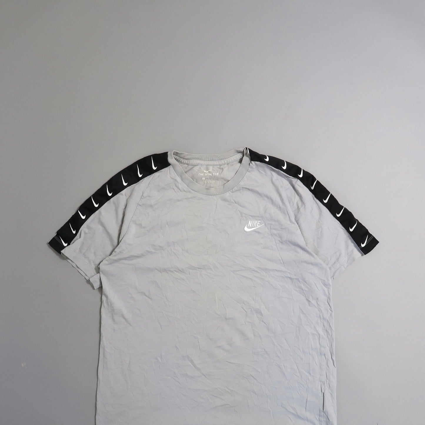 Gray Nike T-shirt with black sleeves featuring white swoosh logos.