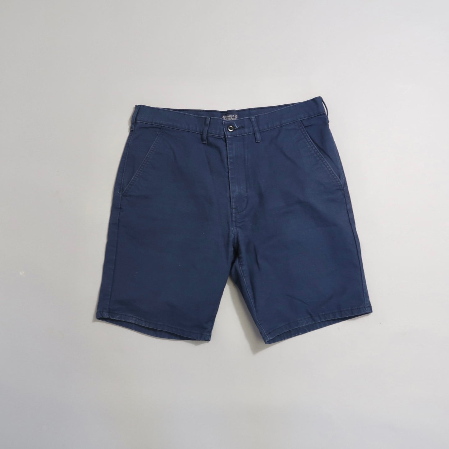 Navy blue shorts on a plain background.