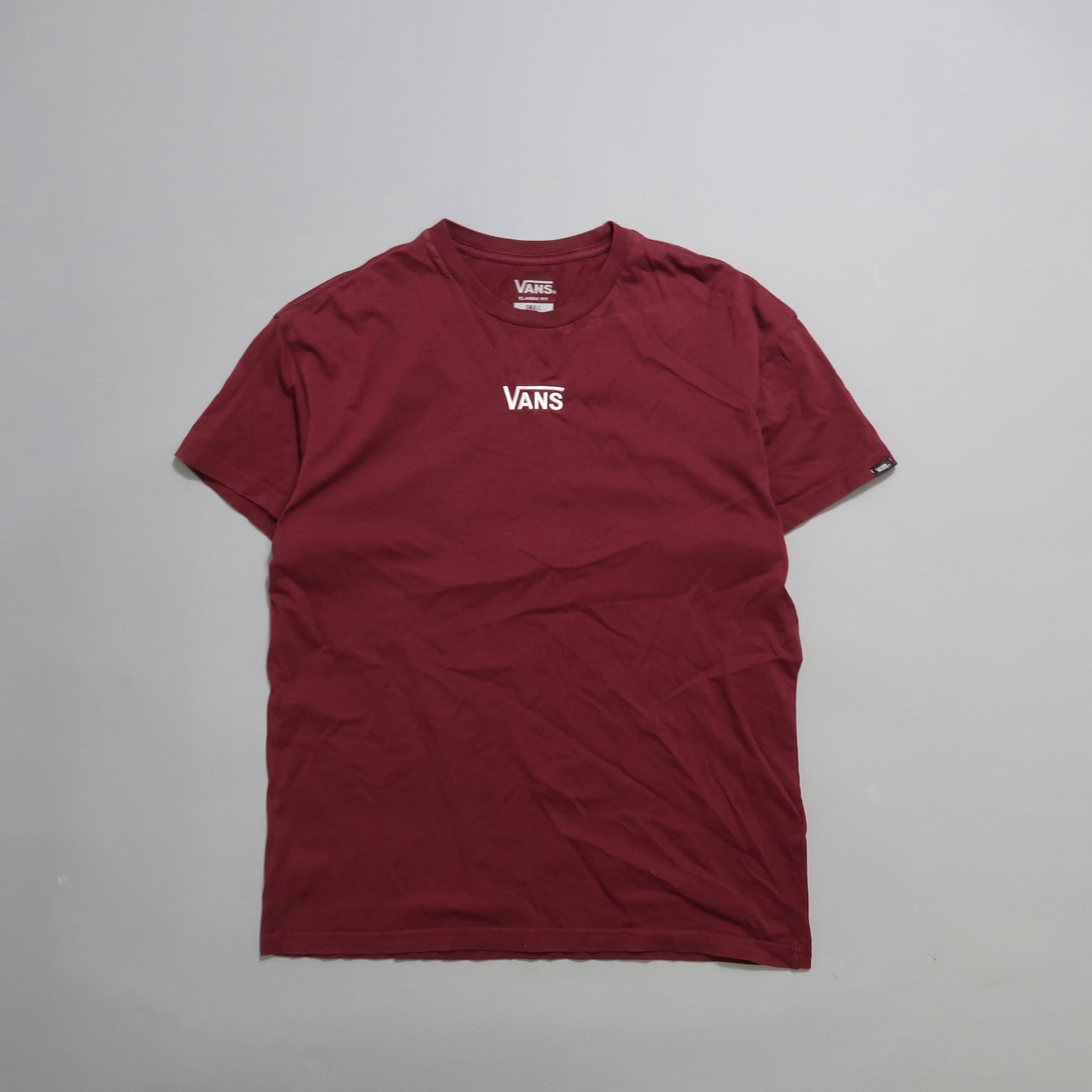 Maroon Vans T-shirt laid flat on a plain background.