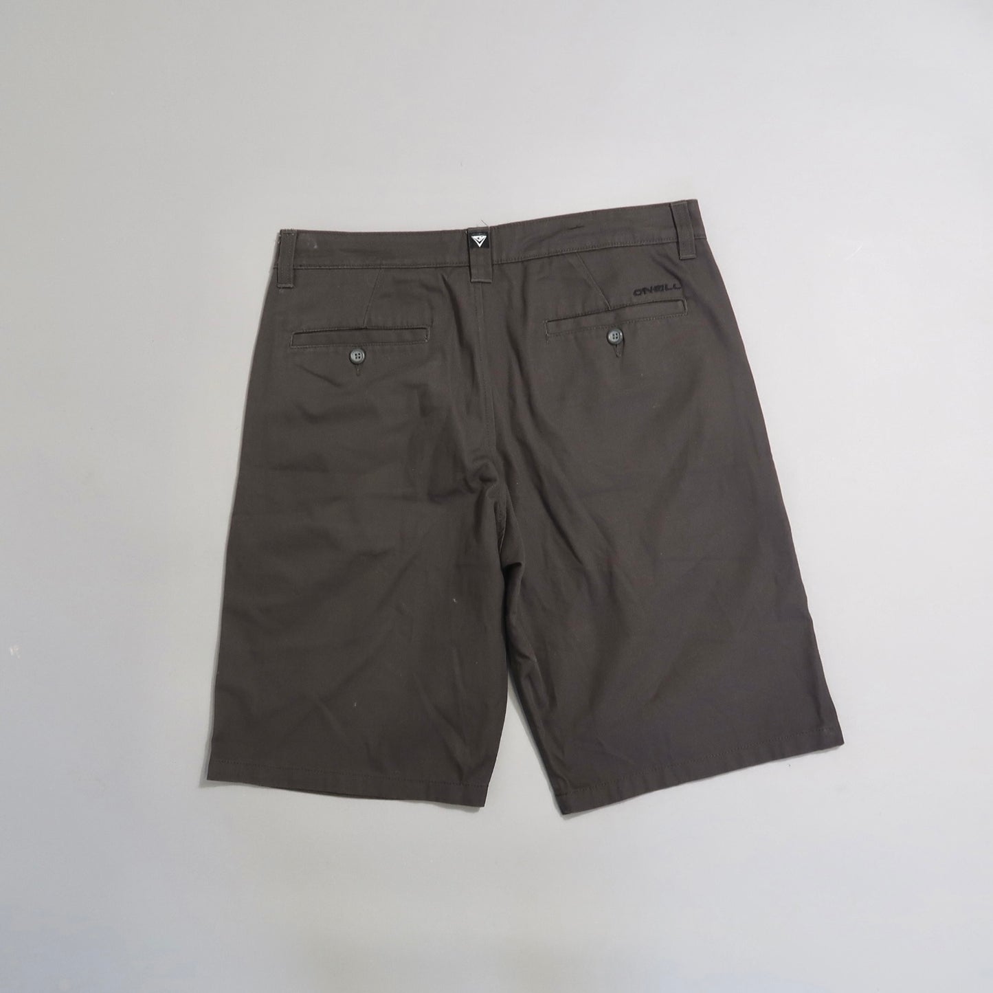Brown shorts with back pockets on a neutral background.