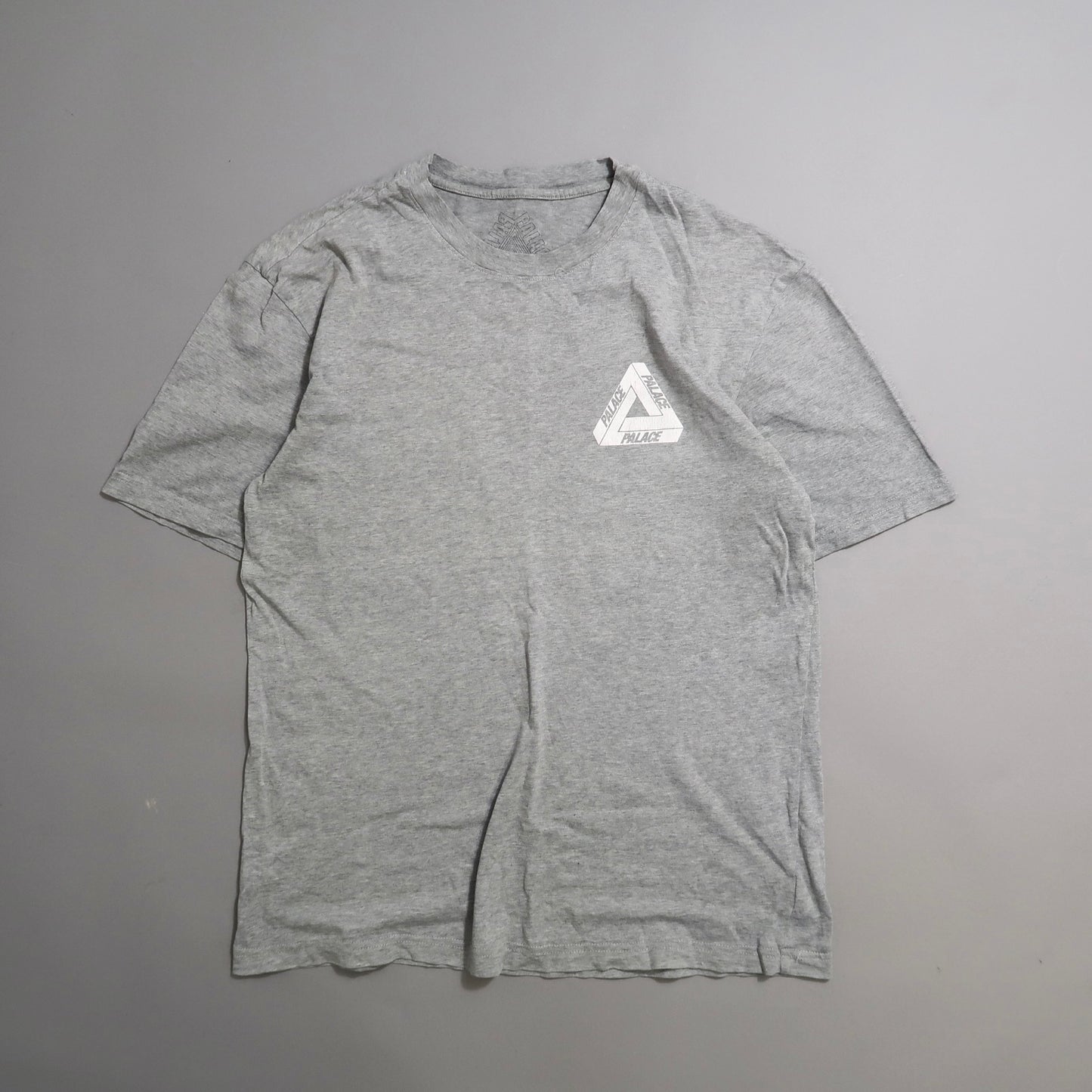 Gray T-shirt with a small triangular logo on the chest.
