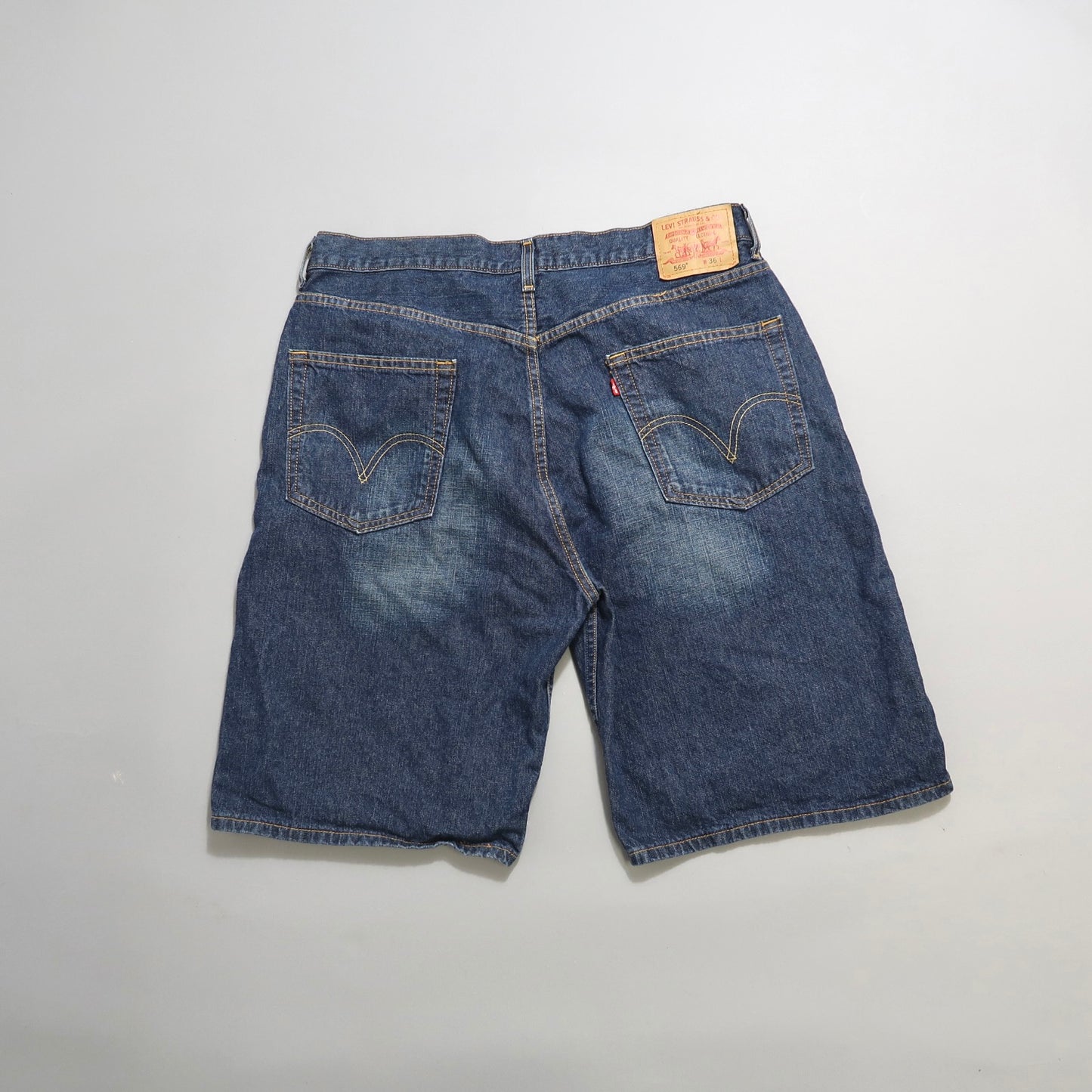 Back view of denim shorts with faded areas and rear pockets.