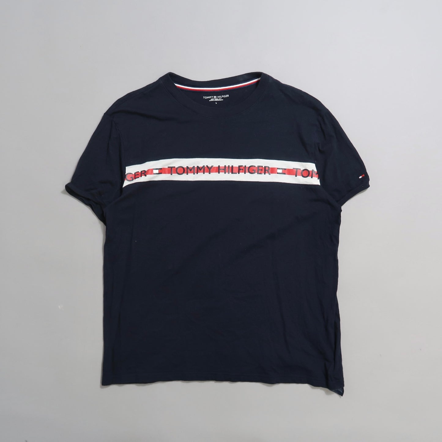 Navy blue Tommy Hilfiger shirt with logo stripe across chest.