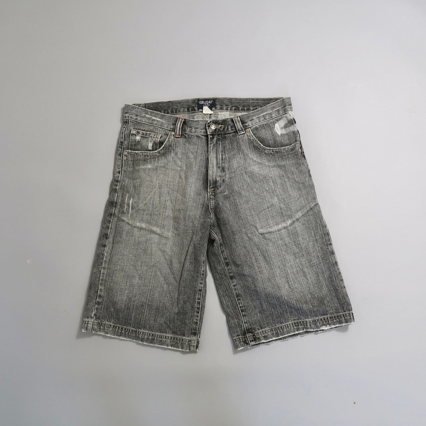 Worn gray denim shorts on a plain background.