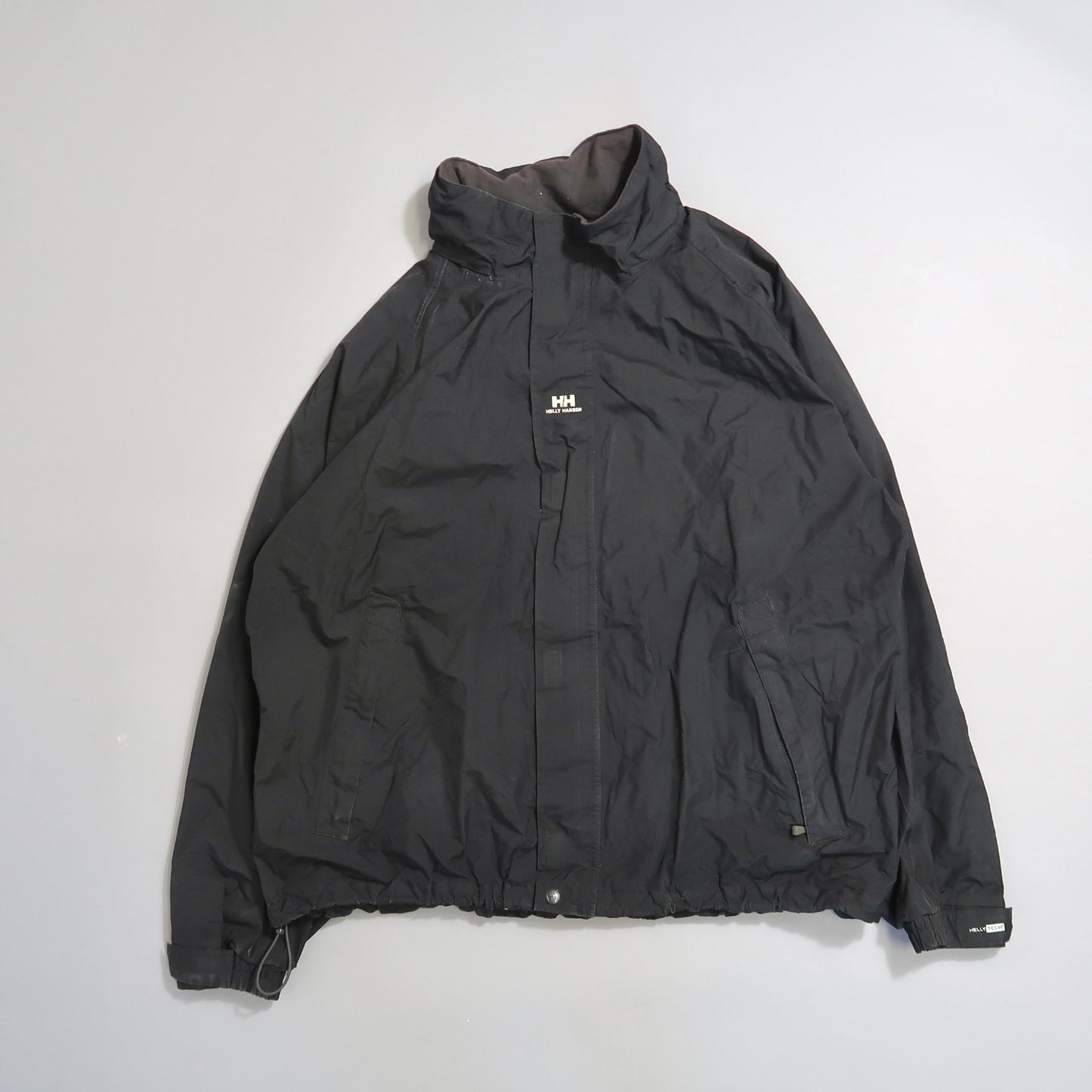 Black jacket with a high collar and small logo on the front.