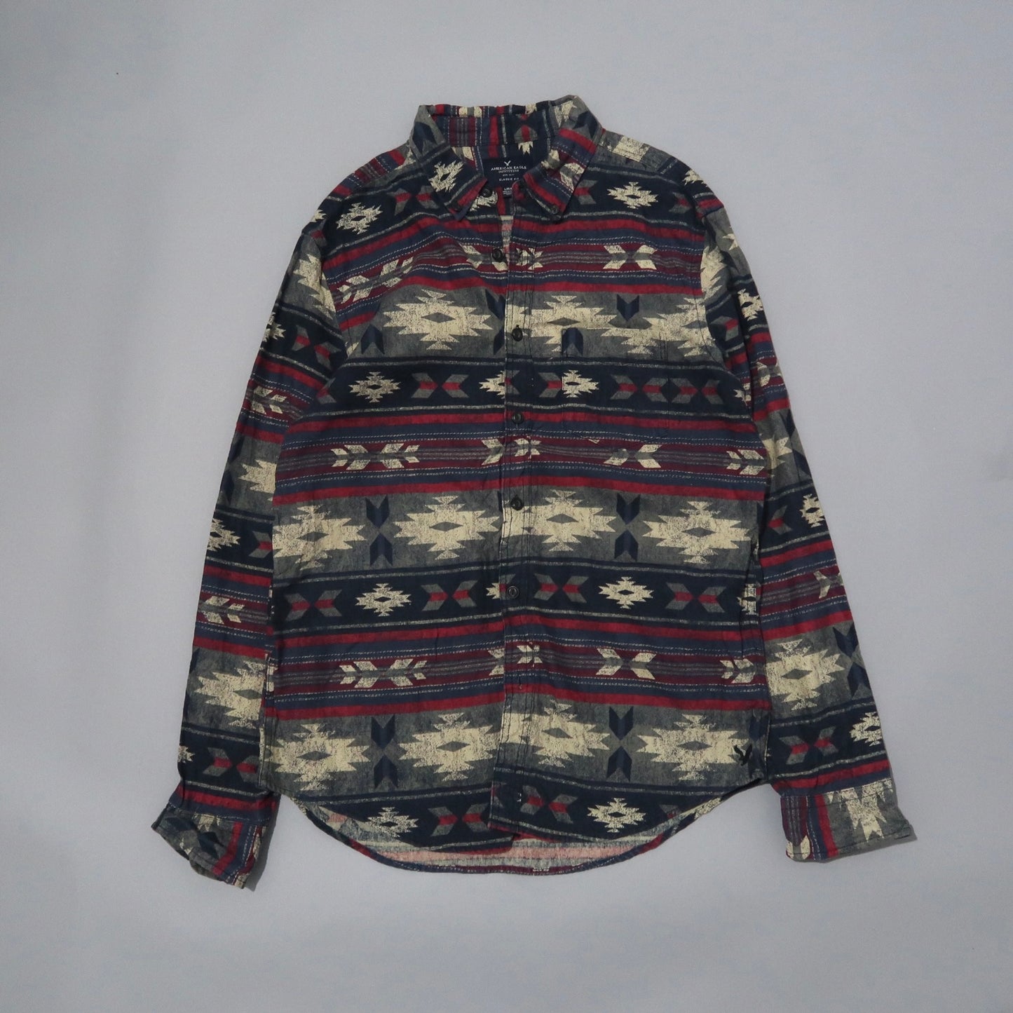 Patterned long-sleeve button-up shirt with red, navy, and beige design.