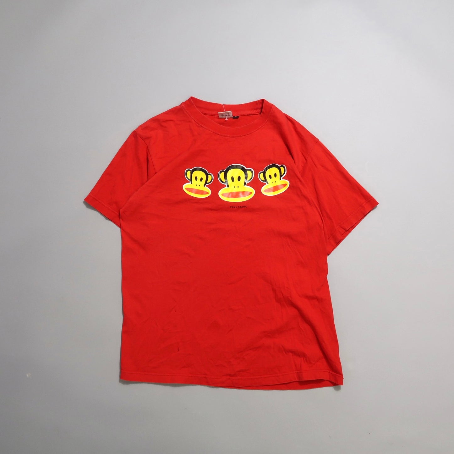 Red T-shirt with three yellow monkey faces design on the front.