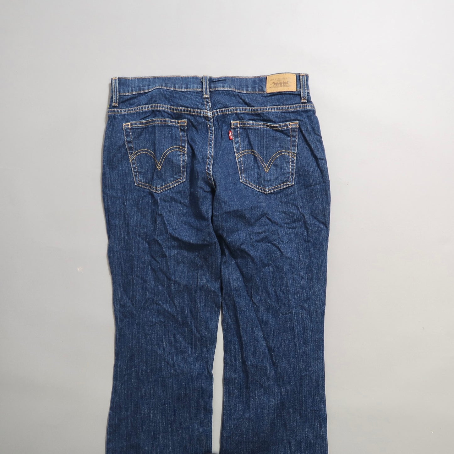 Back view of blue denim jeans with visible pockets and belt loops.