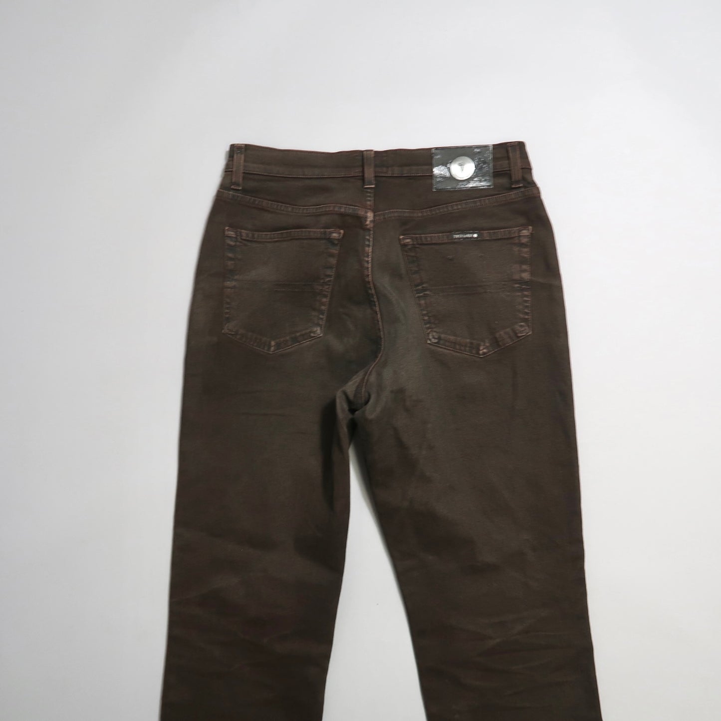 Back view of brown jeans on a white background.