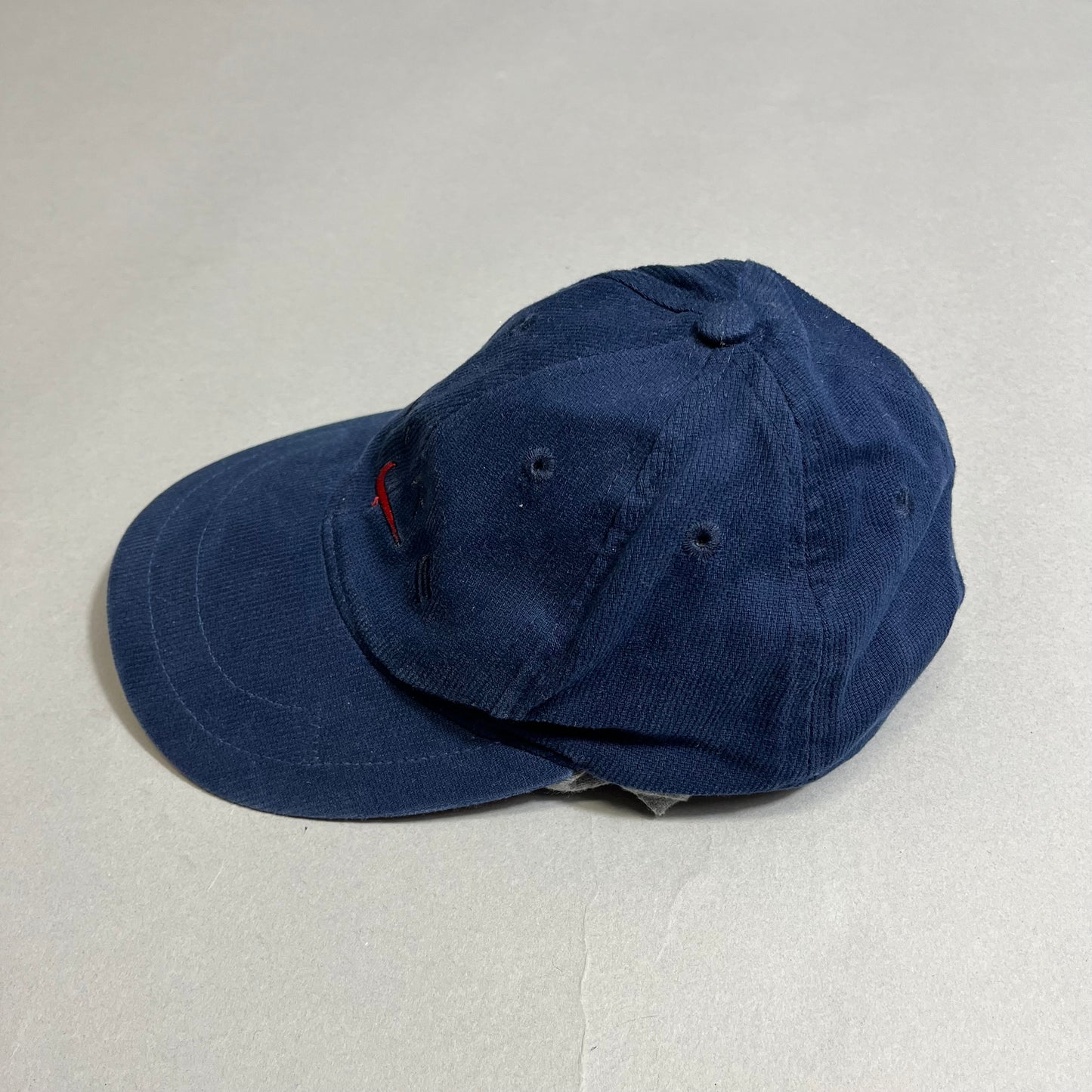 A navy blue baseball cap on a plain gray background.