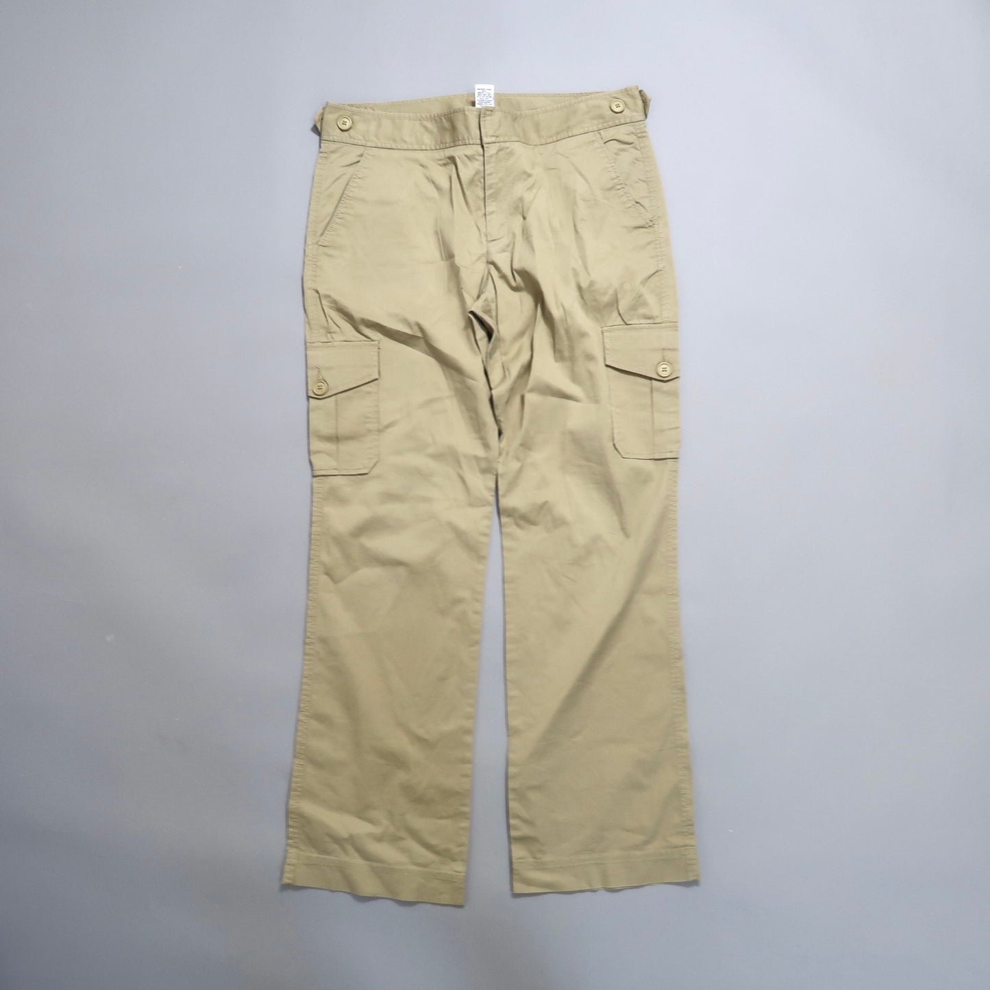 Khaki cargo pants with buttoned pockets on a flat surface.