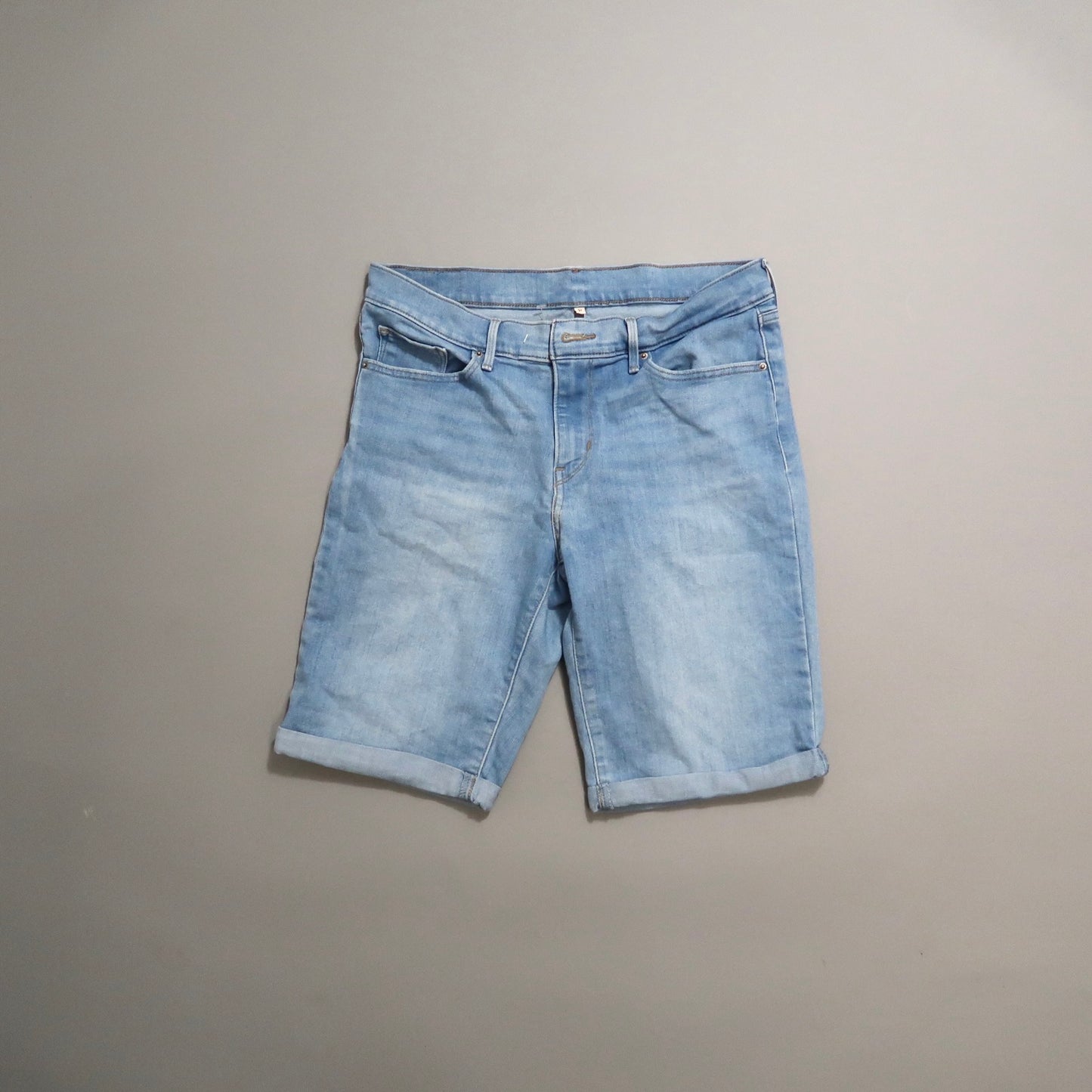 Light blue denim shorts on a plain background.