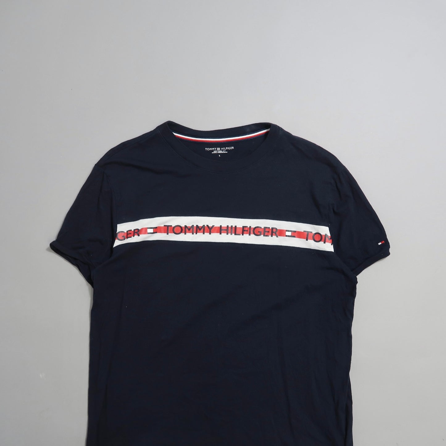 Black Tommy Hilfiger T-shirt with logo and stripe design.