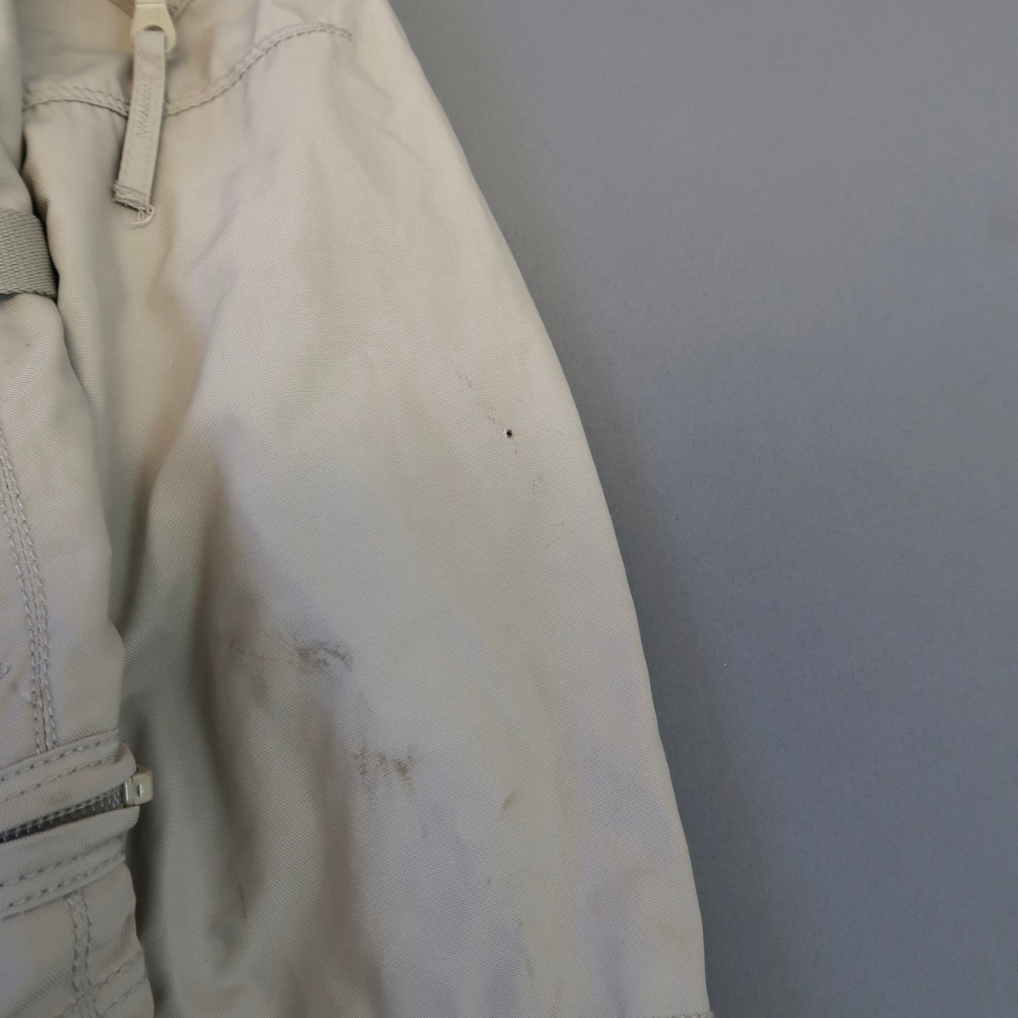 Close-up of a light jacket with small stains on the fabric.