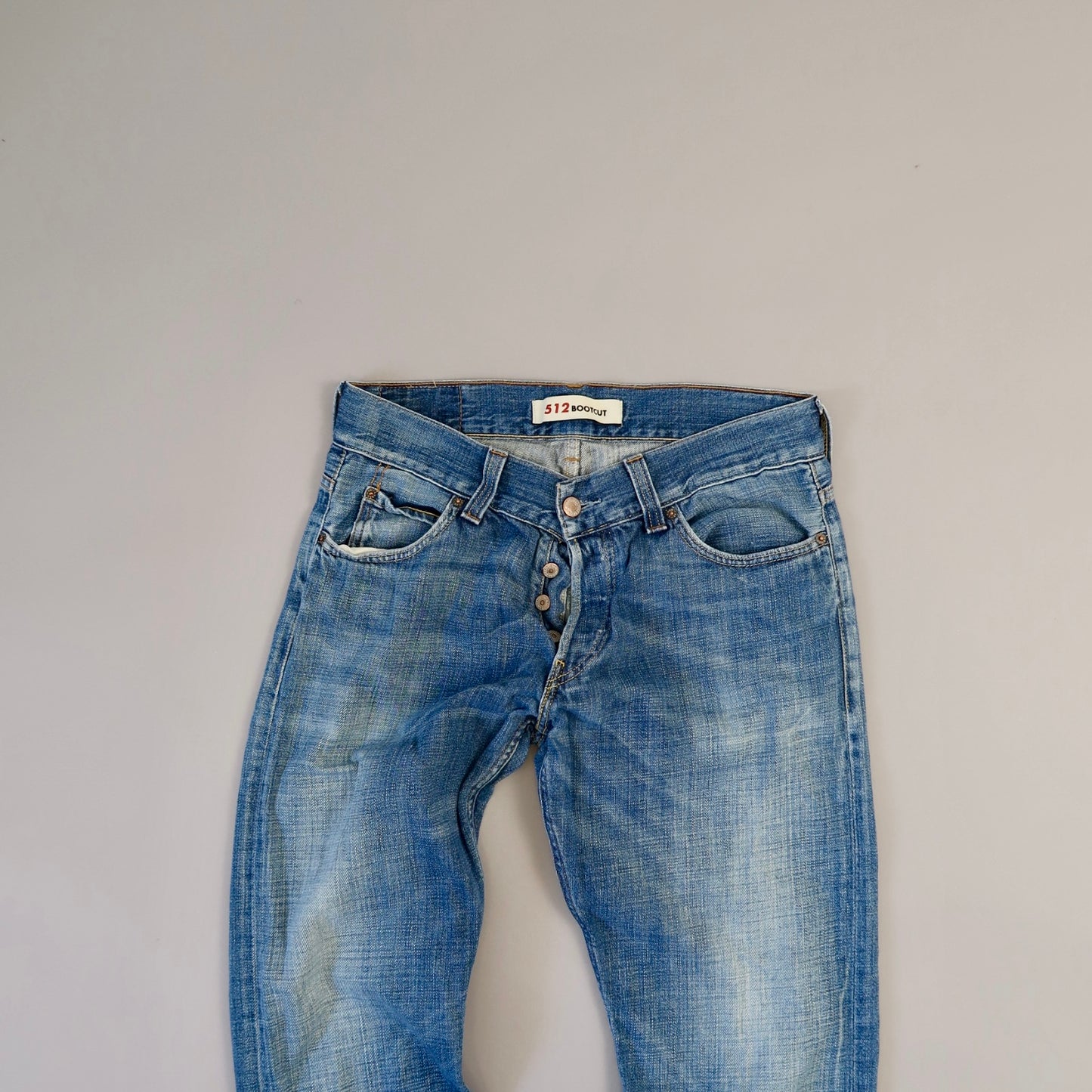 Blue jeans on a flat, neutral background.