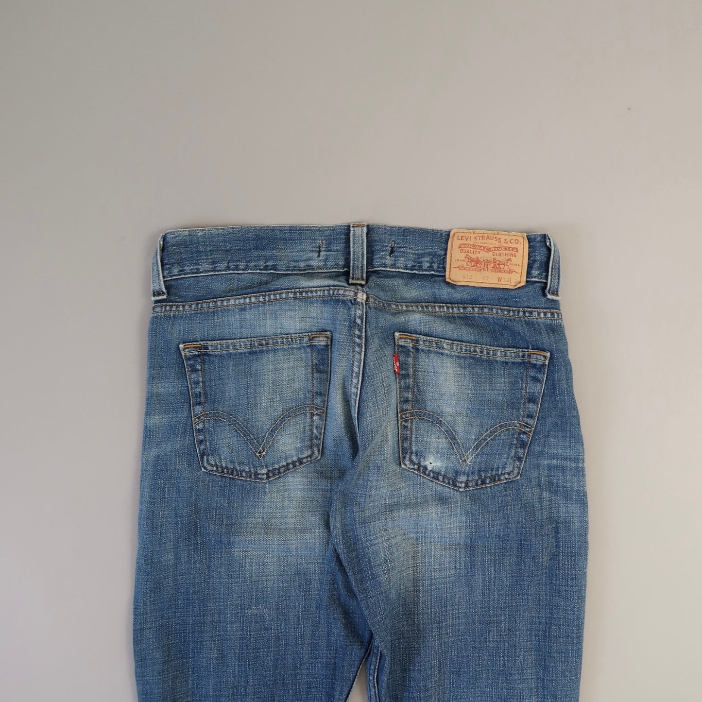 Back view of blue jeans with a leather brand label.