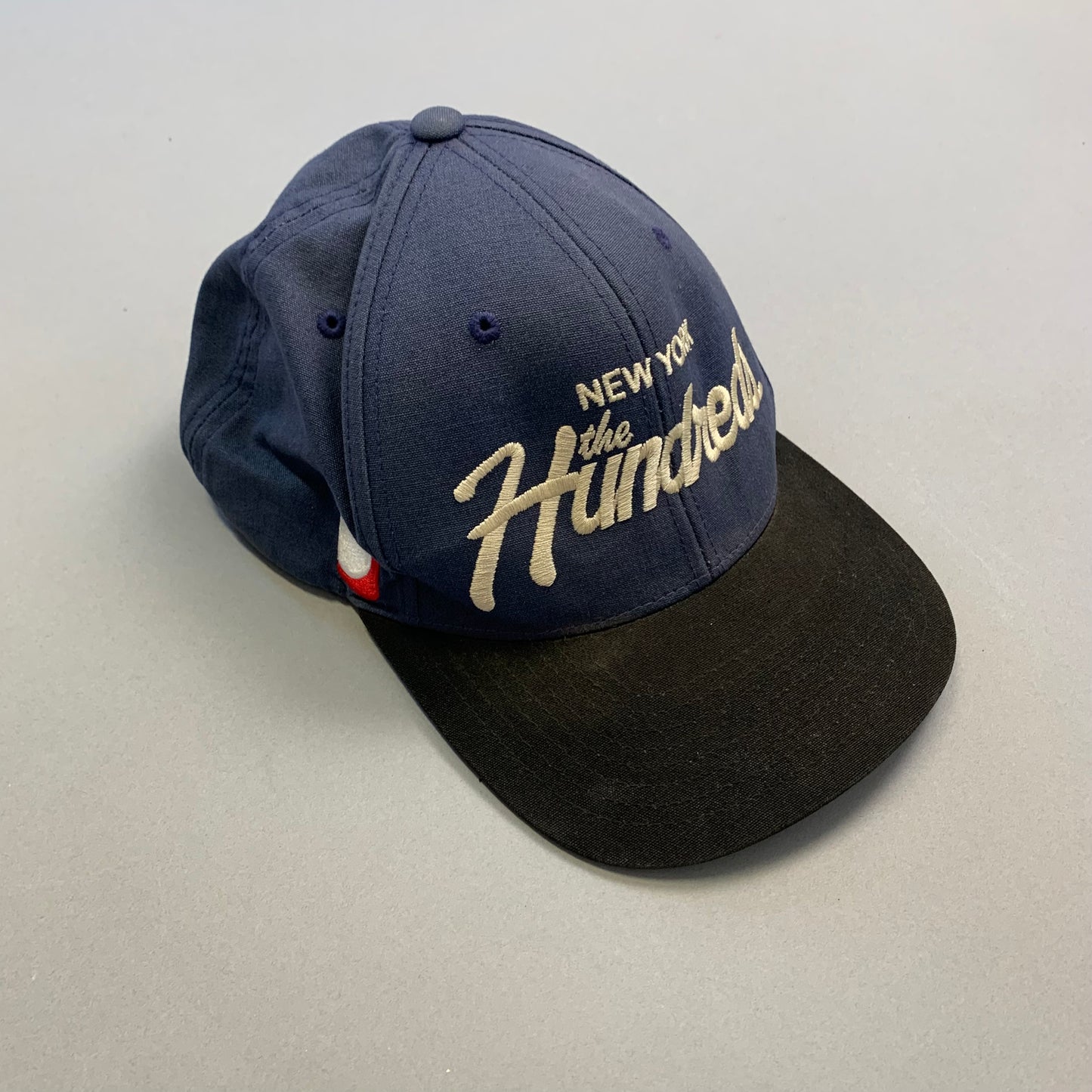 Blue cap with nullNew York the Hundredsnull embroidered text.