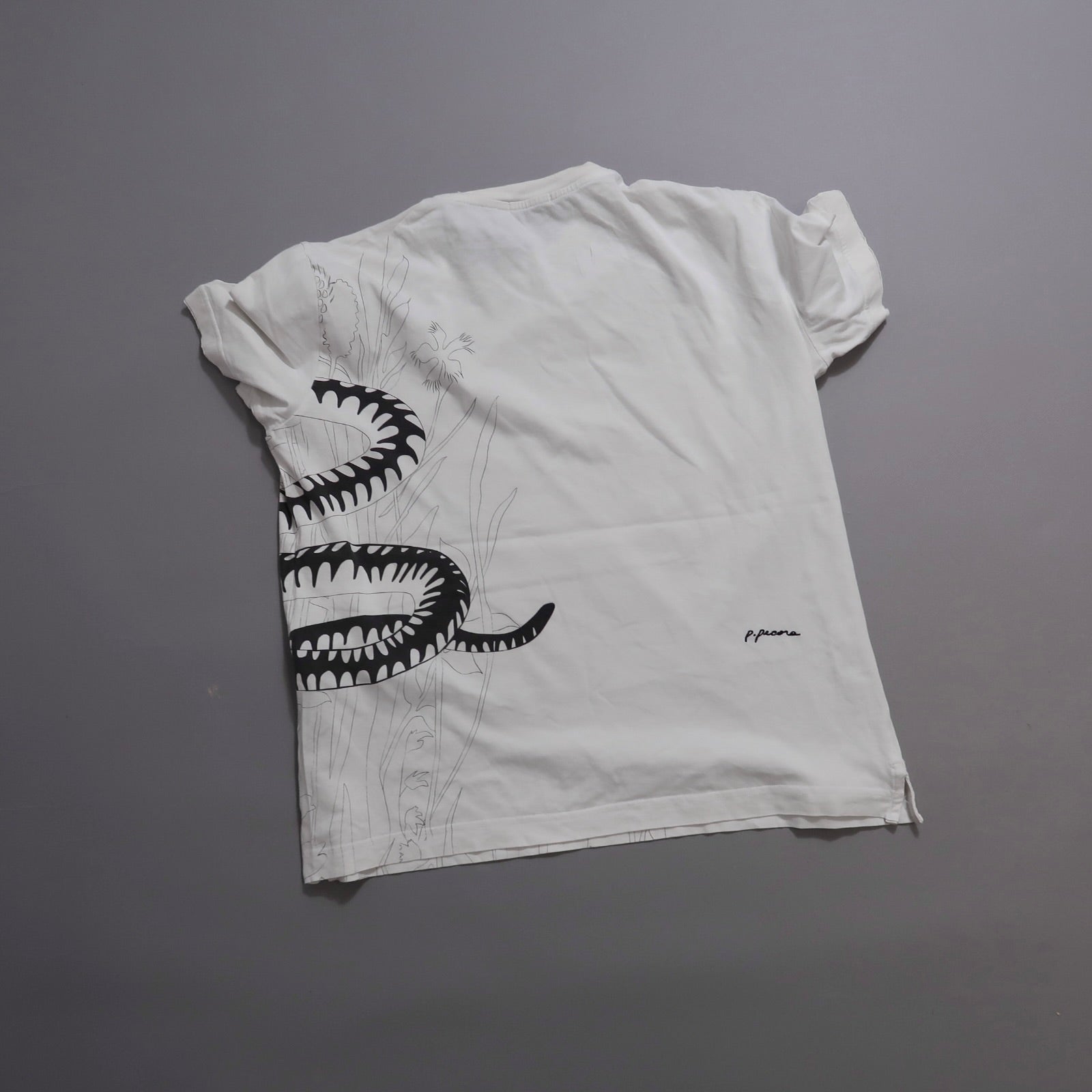 White T-shirt with black snake and floral design on the back.