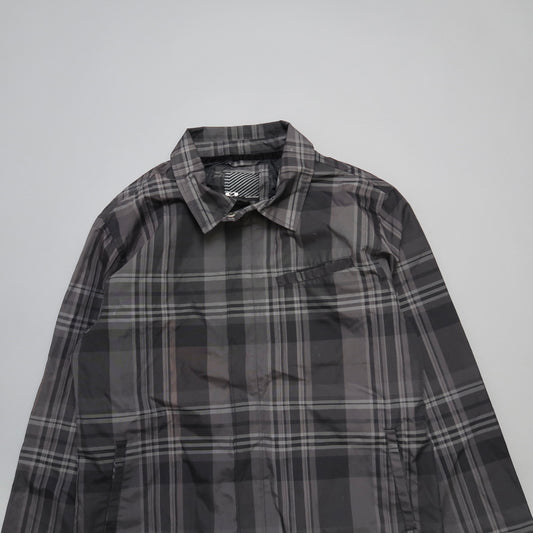 Gray plaid shirt with a collar, laid flat on a white surface.