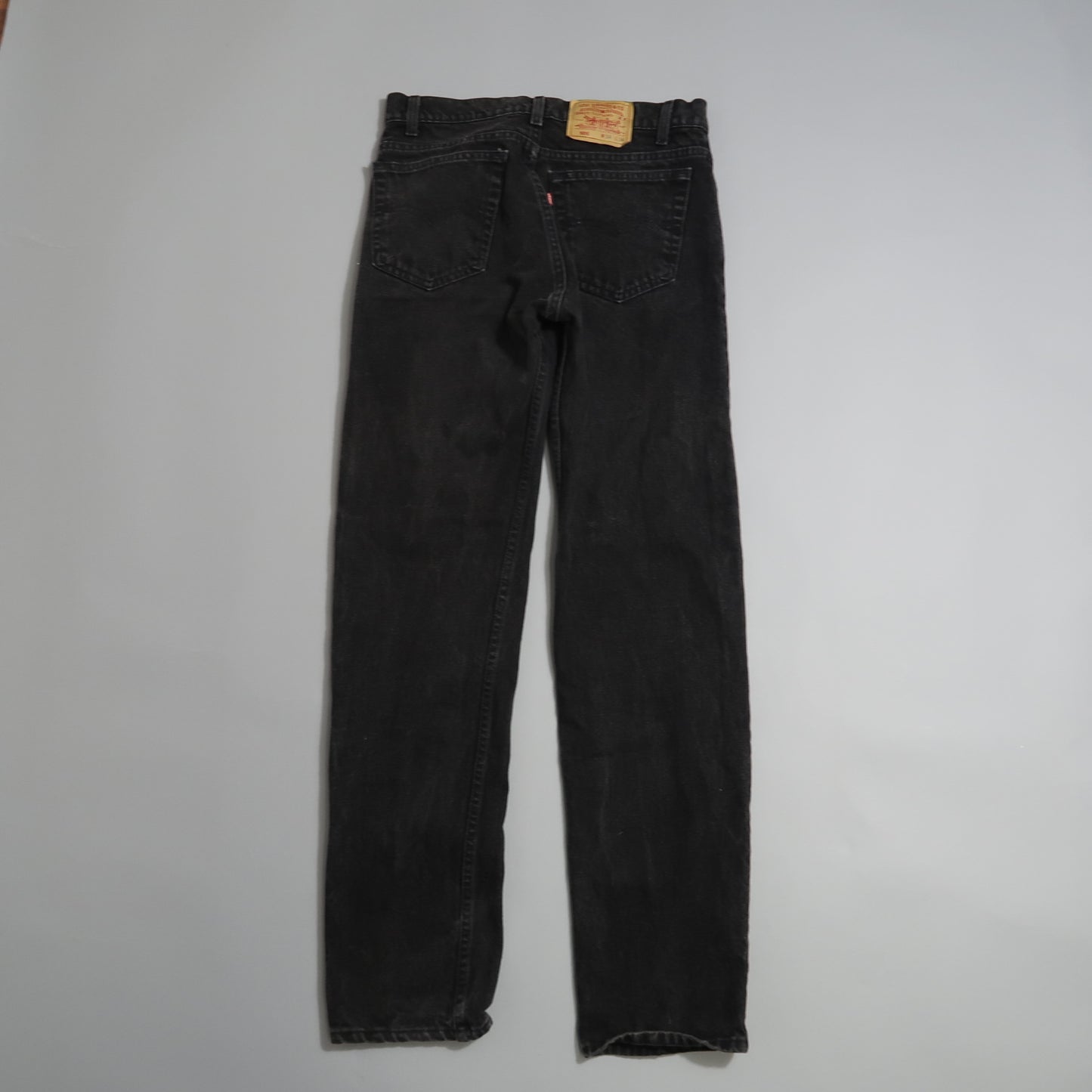 Black jeans displayed on a flat white surface.