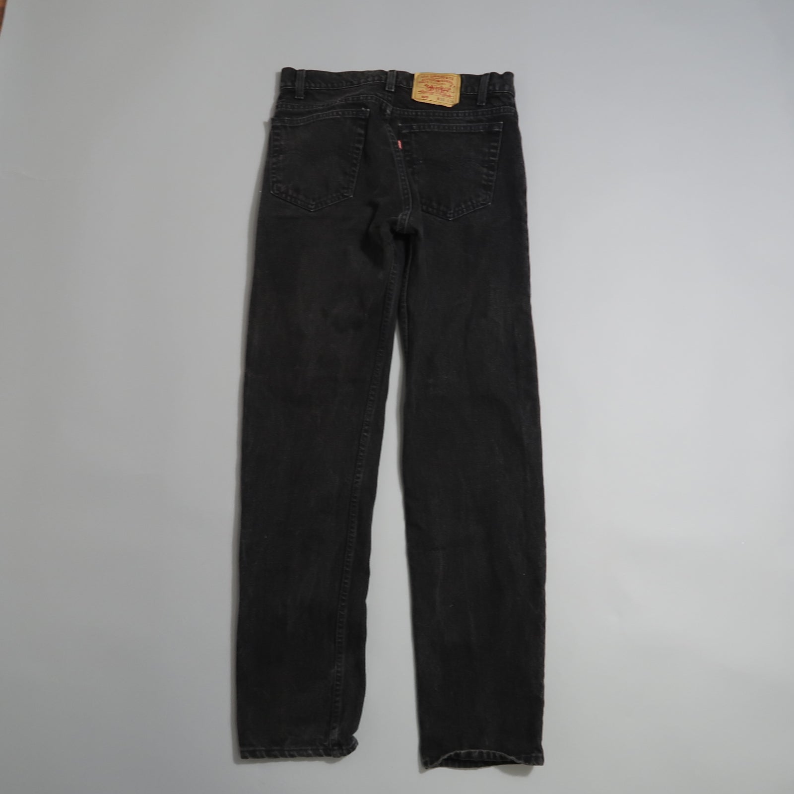 Black jeans displayed on a flat white surface.
