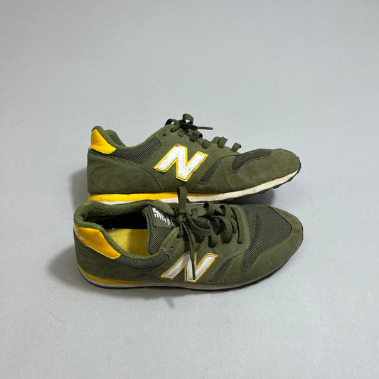Green and yellow sneakers with nullNnull logo on gray background.