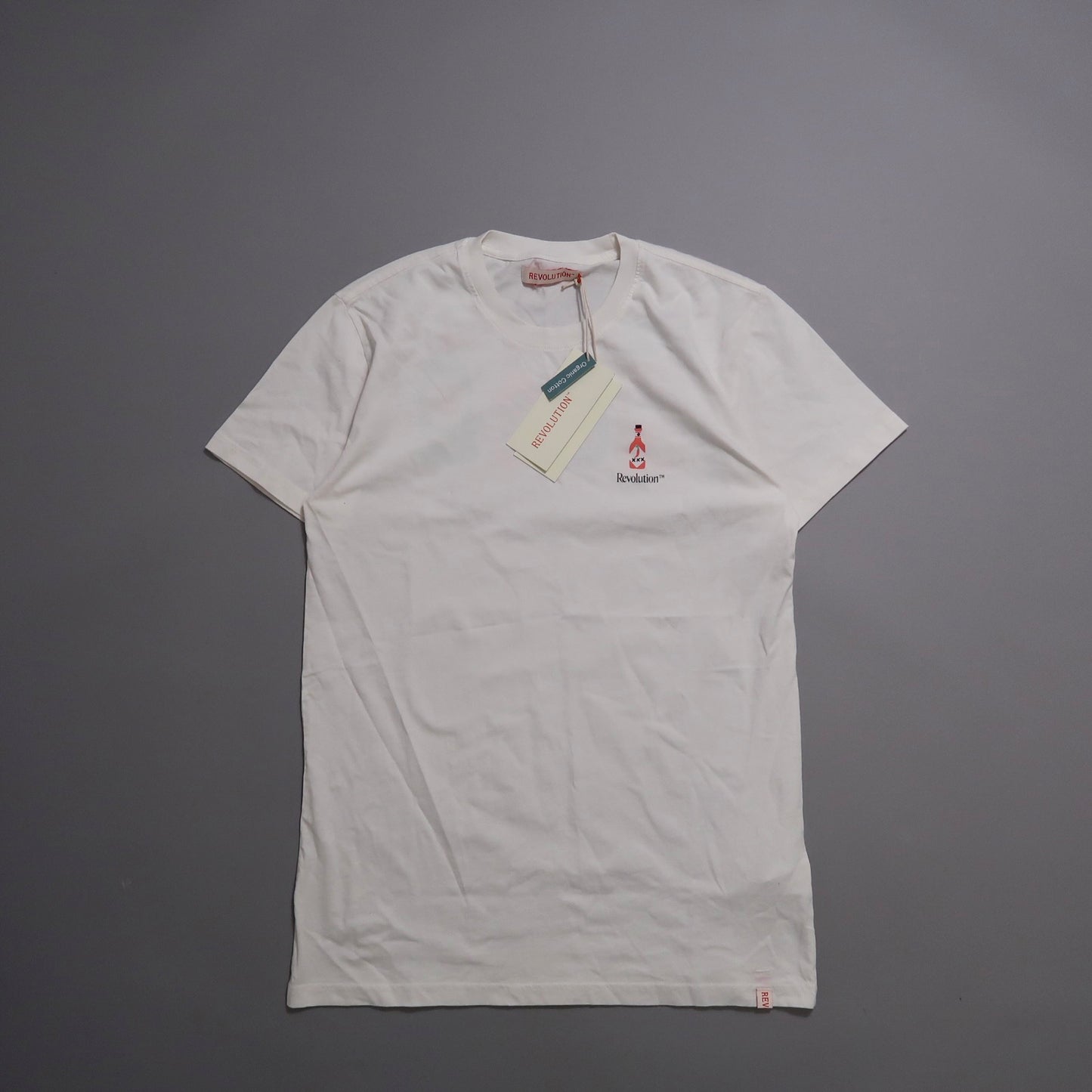 White T-shirt with a small logo and tags on a gray background.